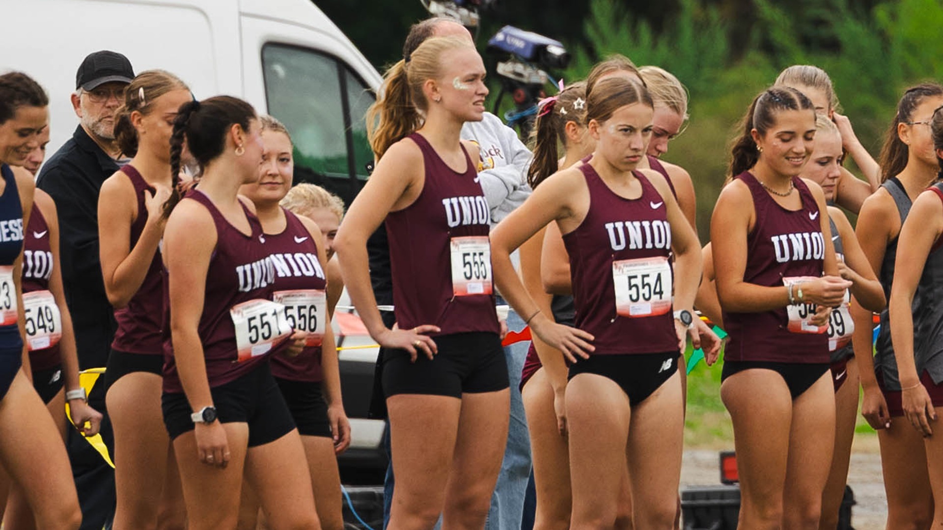 Women's cross country runners stand while awaiting the start of a race.