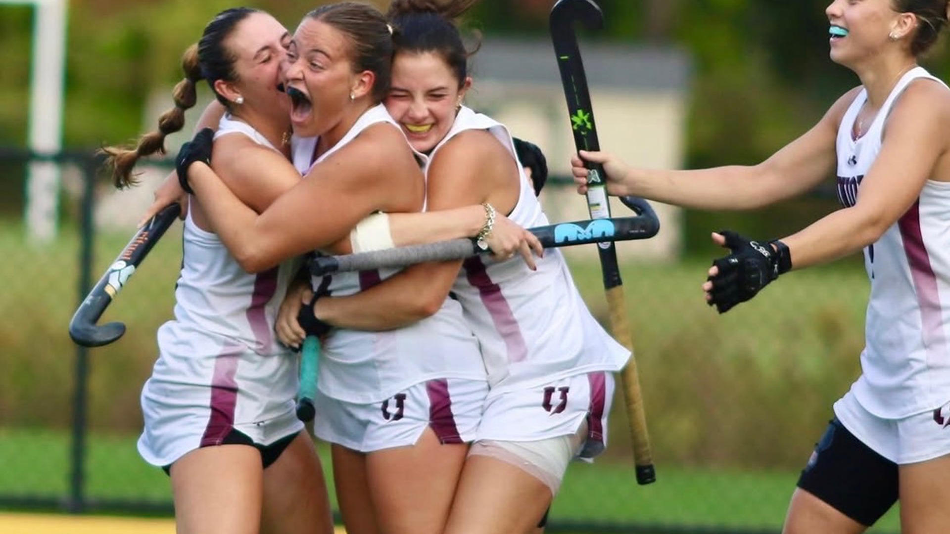 Union field hockey players celebrating a goal.