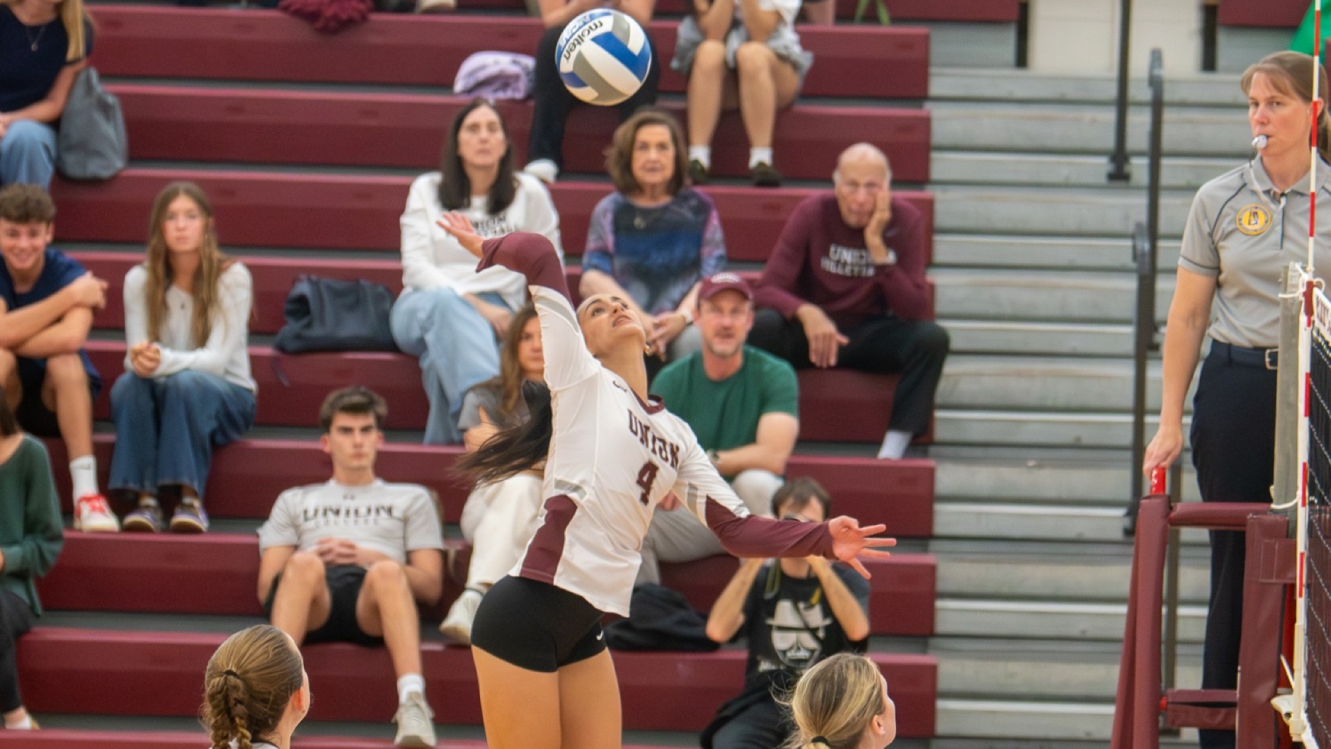a women's volleyball player hitting a volleyball