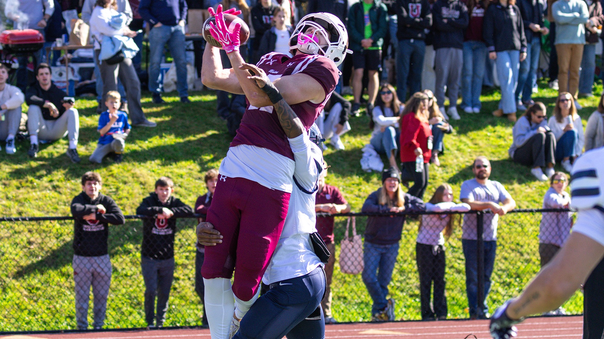 A Union football player catches a touchdown pass while being defended by an opponent.