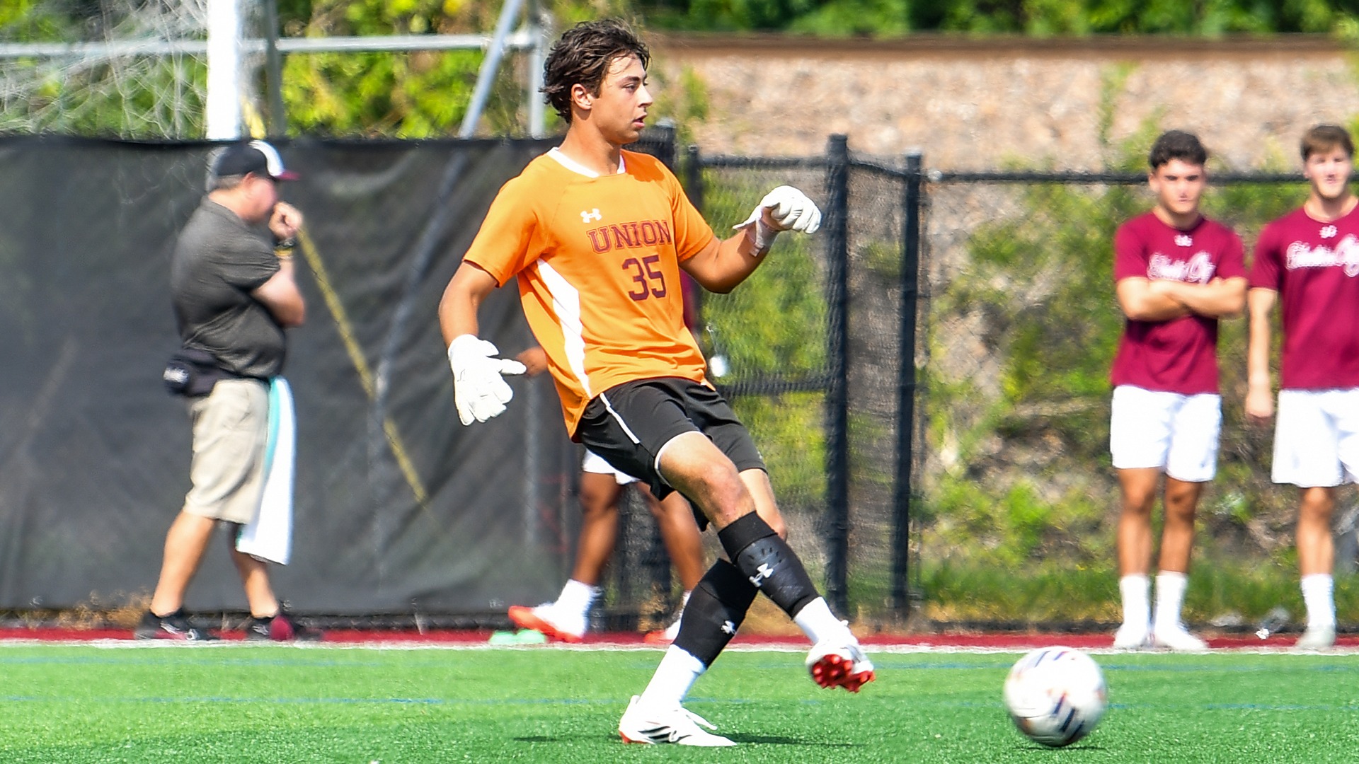 A men's soccer goalie kicks the ball.