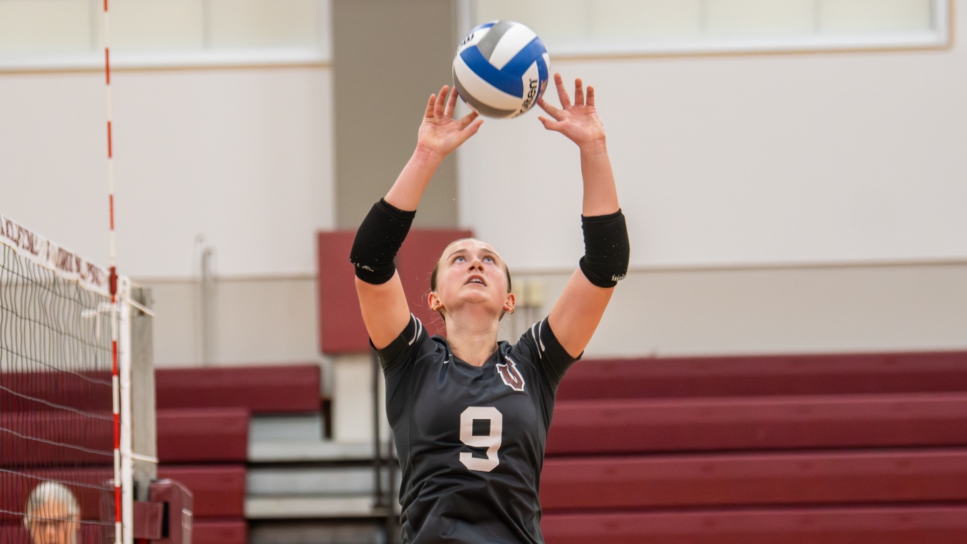 a women's volleyball player setting a ball
