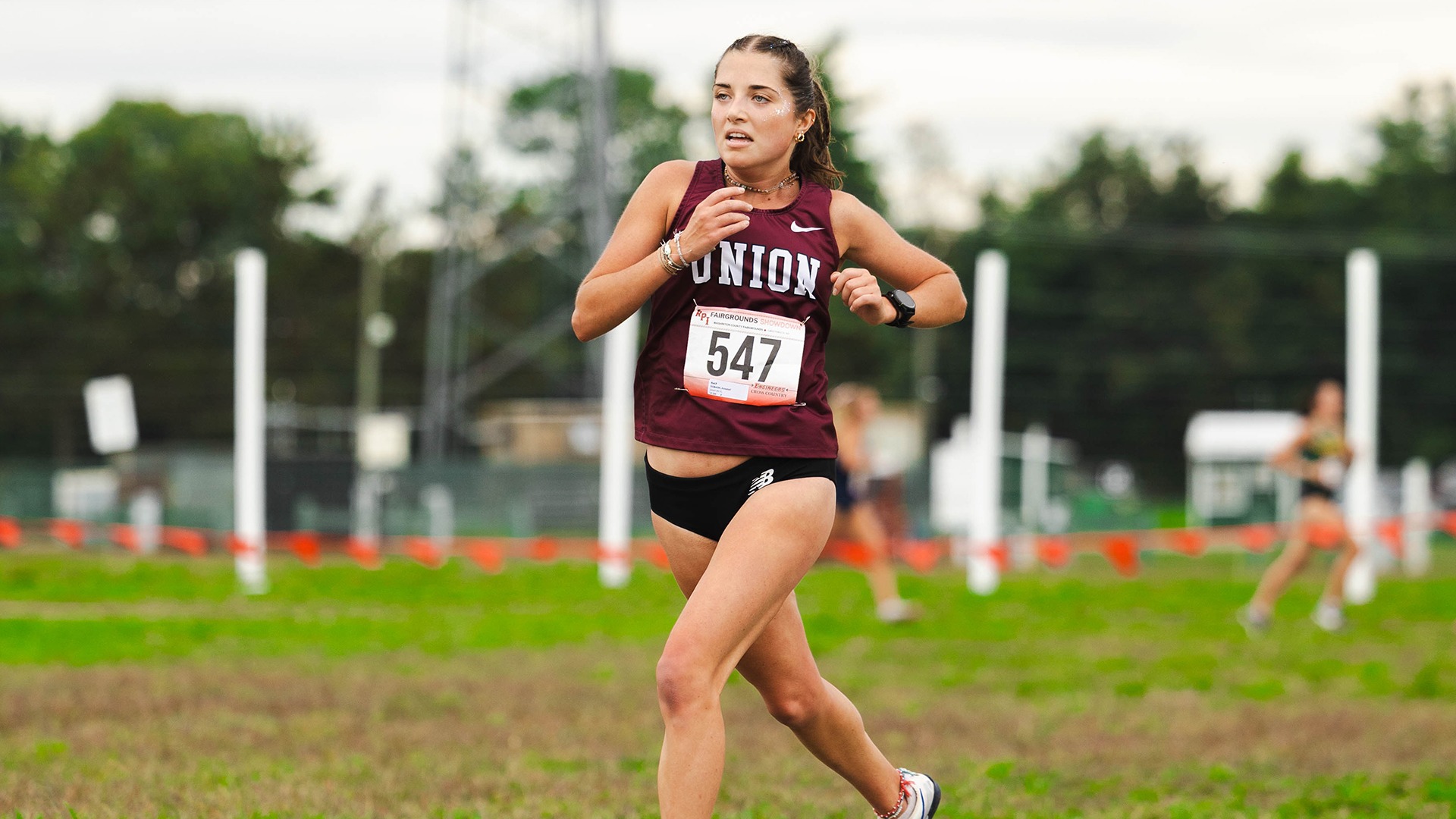 A runner running by herself on a cross-country course.