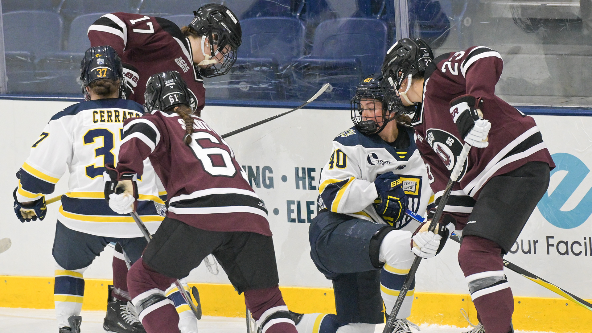 WHOC players fighting for puck against boards 