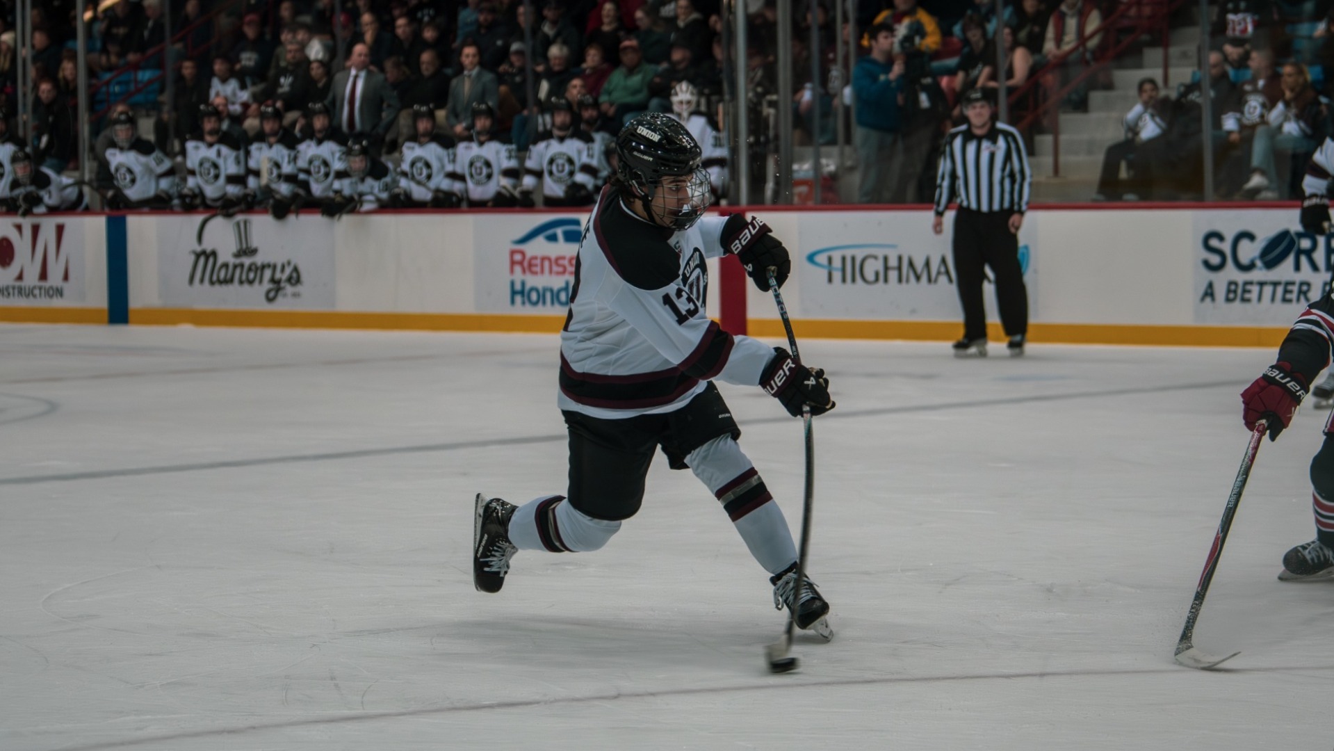 a men's hockey player taking a shot with some stick bend
