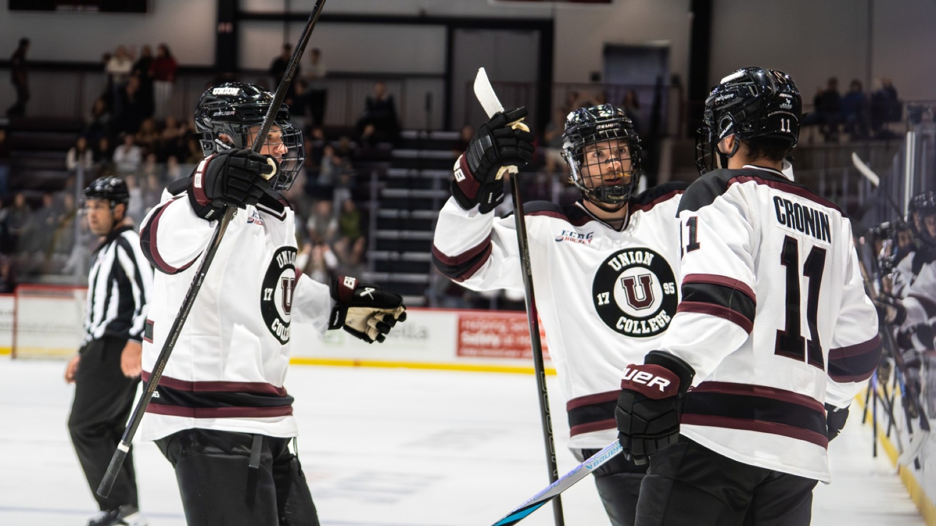 three hockey players about to hug after scoring a goal