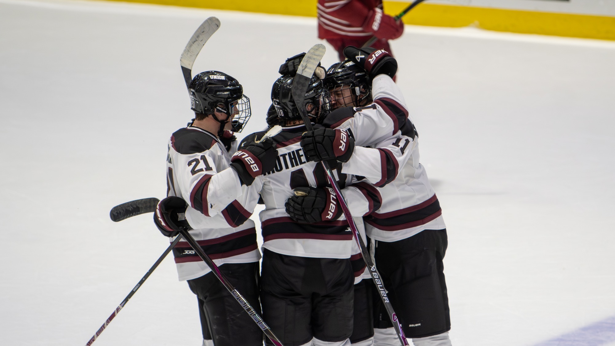 men's hockey team hugging to celebrate a goal