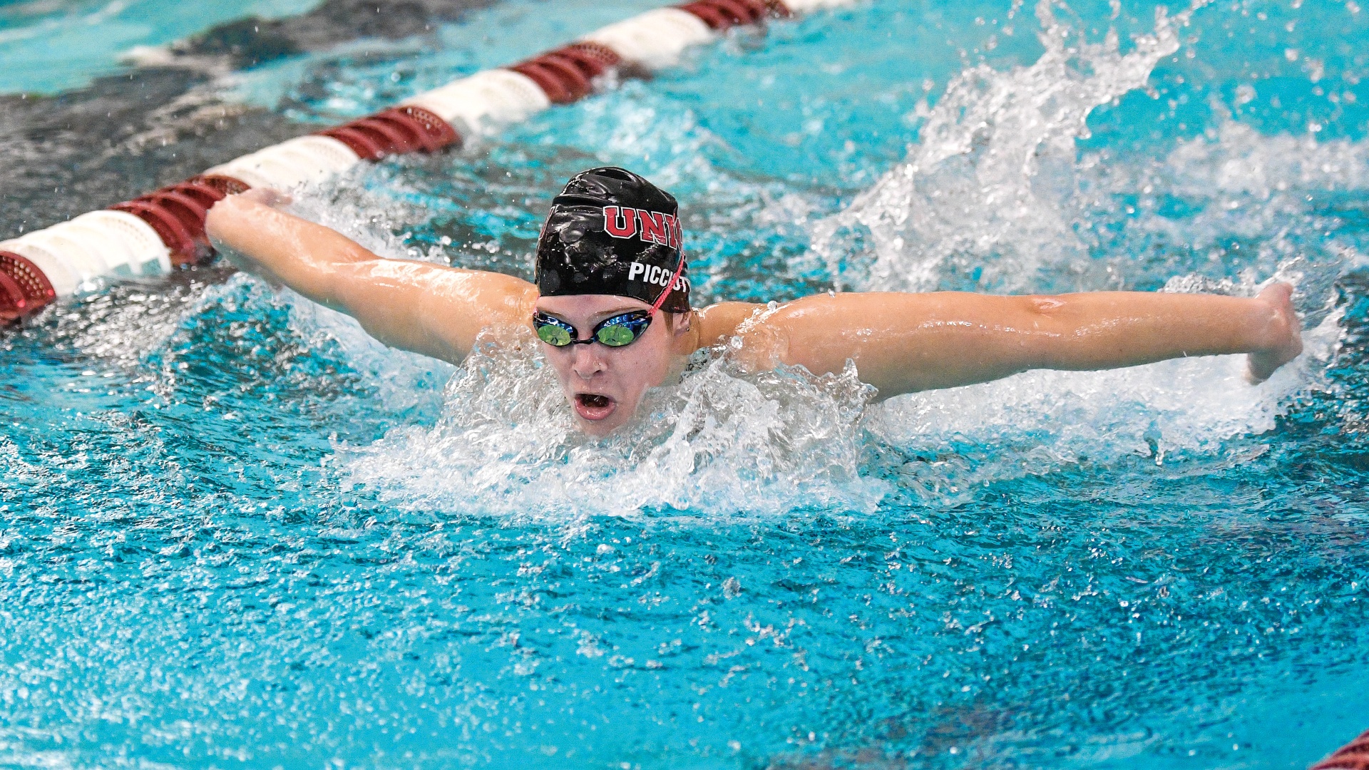 women's swimmer performing the butterfly, swimming towards the camera