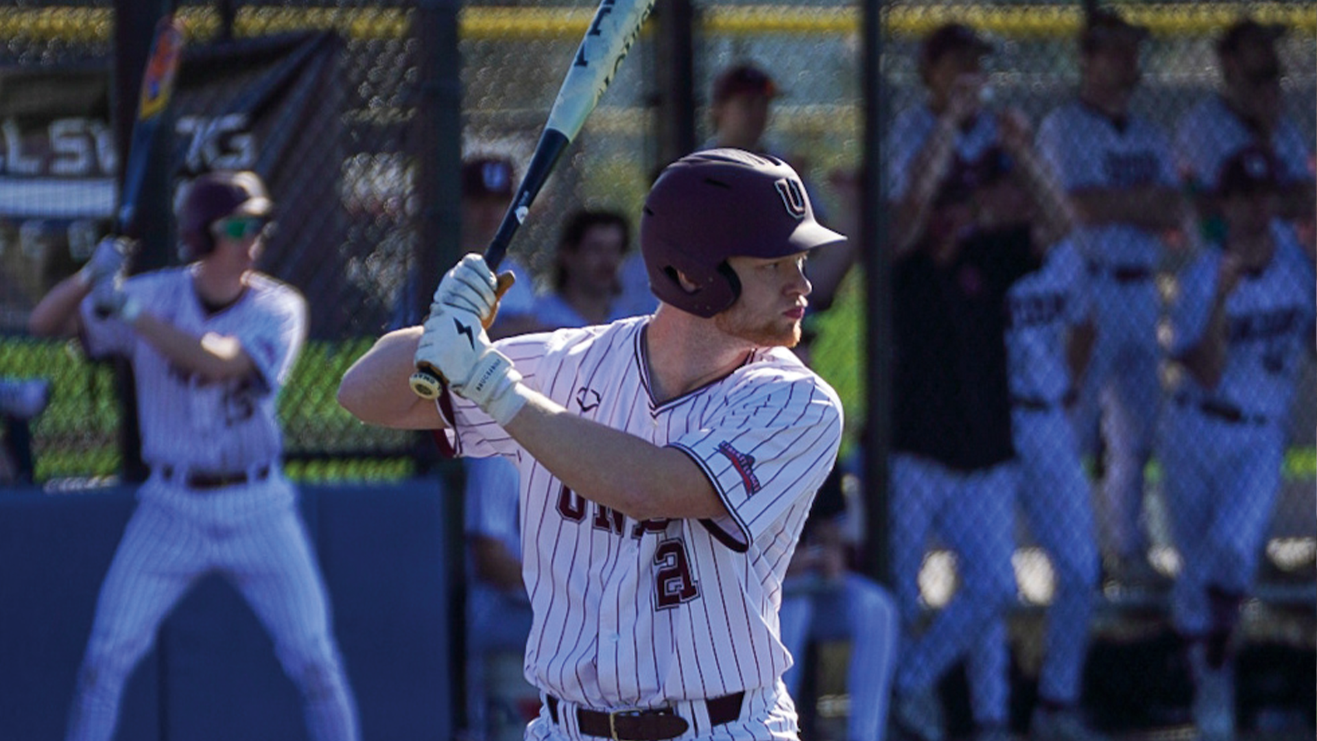 a photo of a baseball player from the waist up in his batting stance, awaiting a pitch