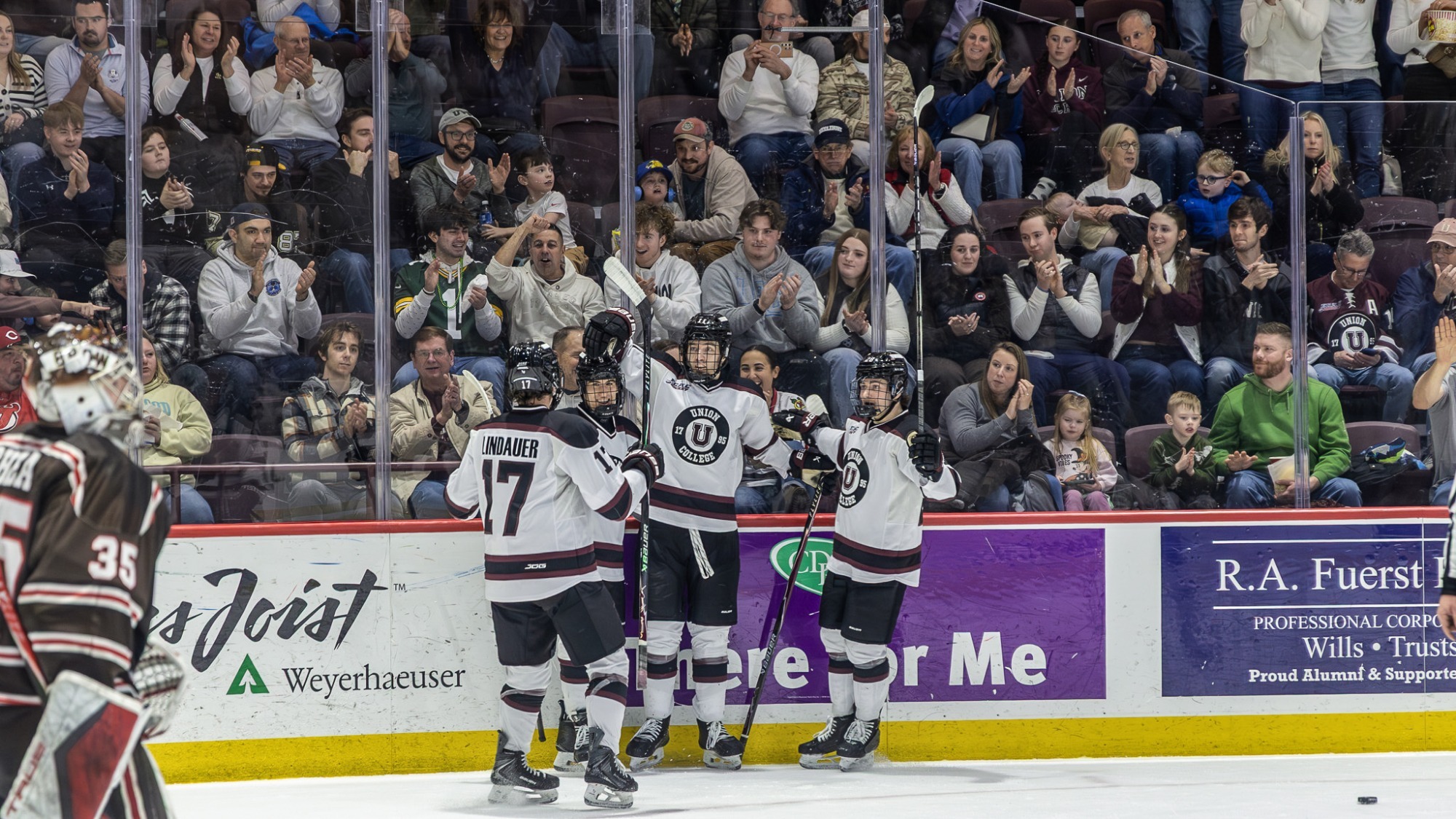 men's hockey team celebrating after a goal by hugging each other