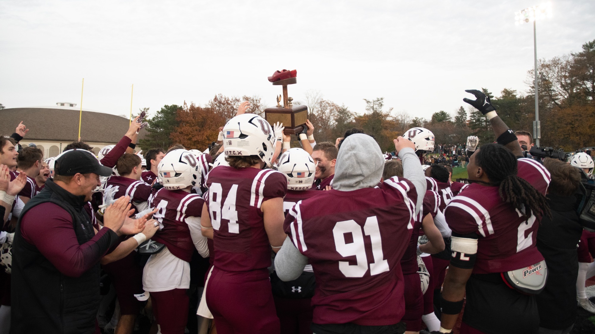 Football Players Raising Dutchman Shoes Trophy