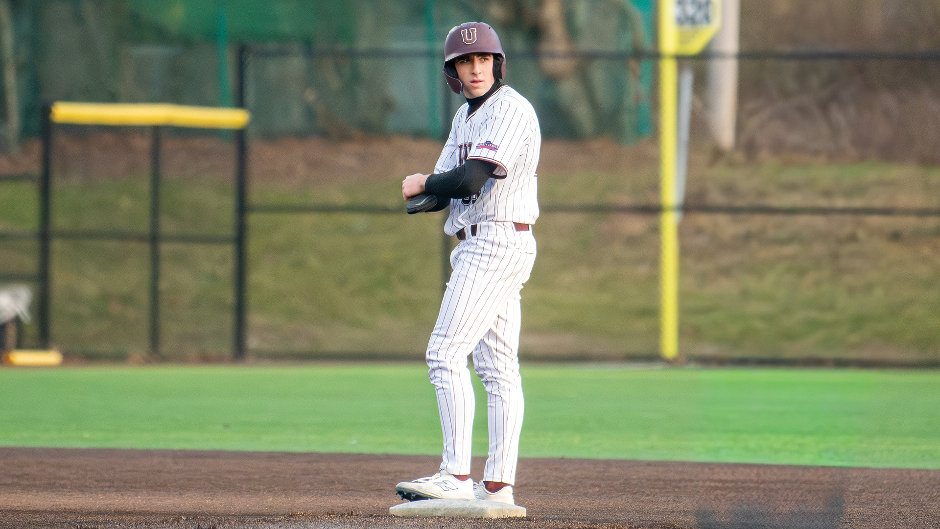 a baseball player standings on second base looking over his shoulder