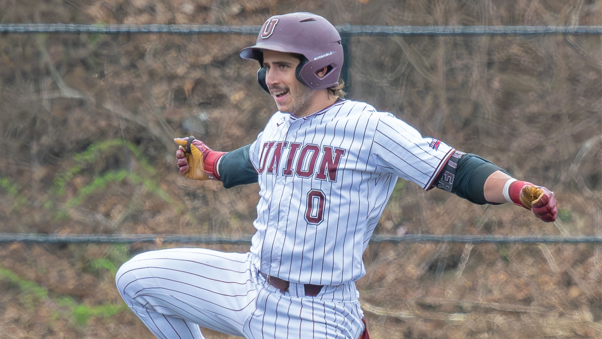 a baseball player celebrating with his arms up in the air and smiling