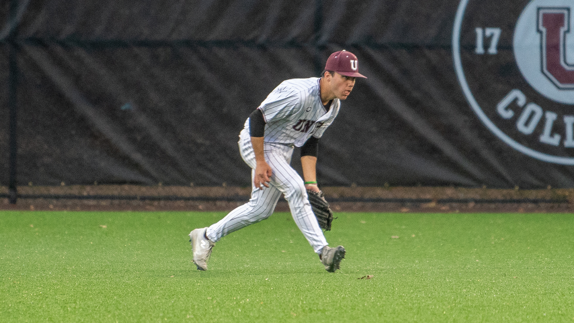a baseball player fielding a ball in the outfield