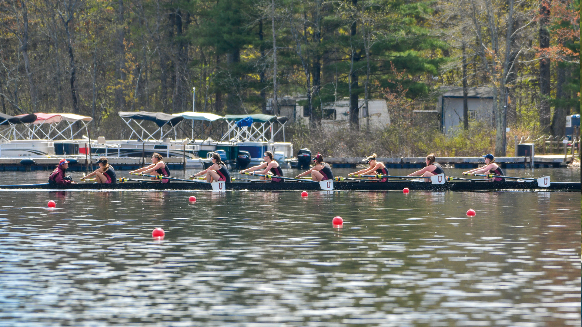 a women's crew team racing in a black boat