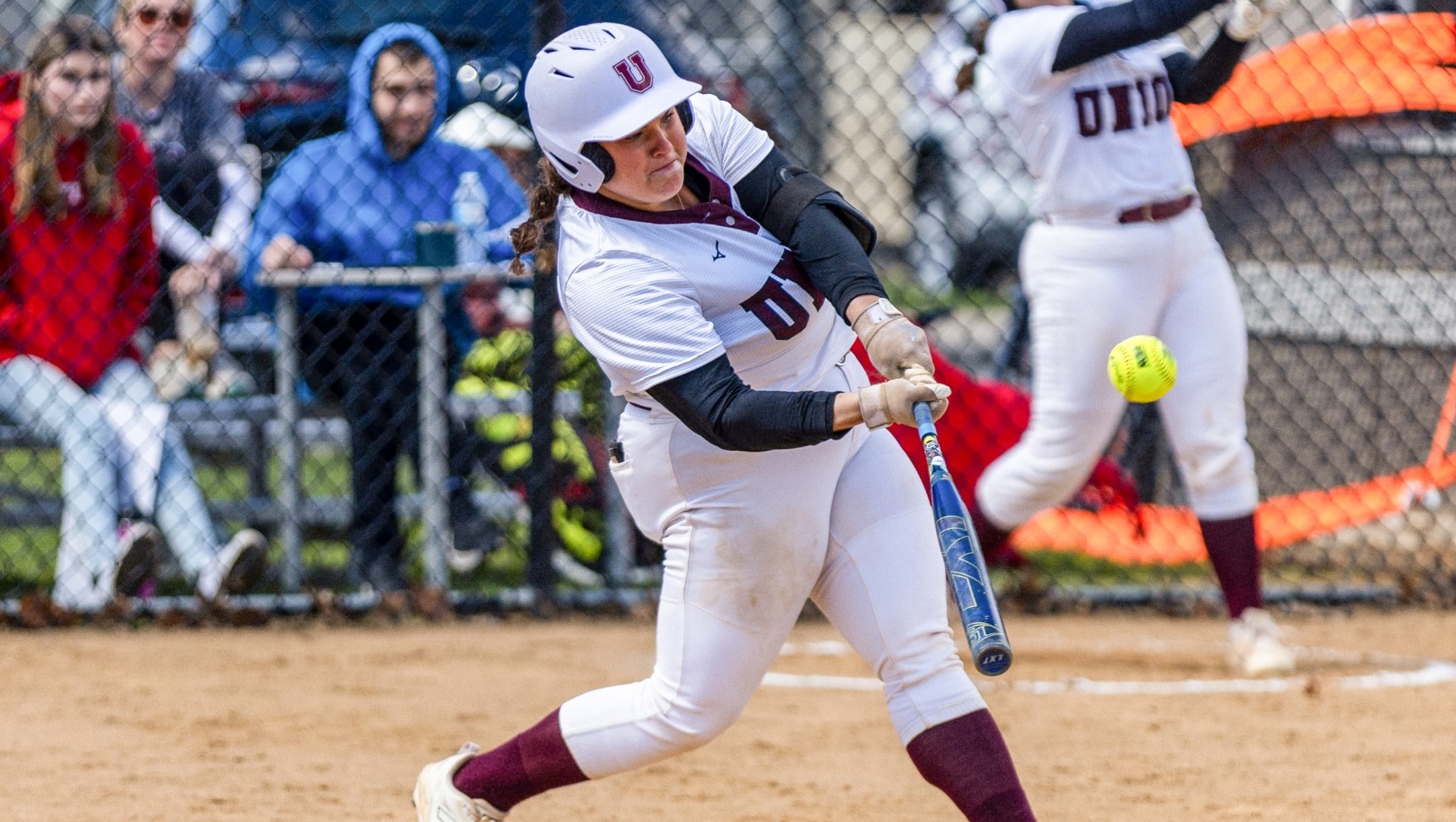A softball player hitting the ball.