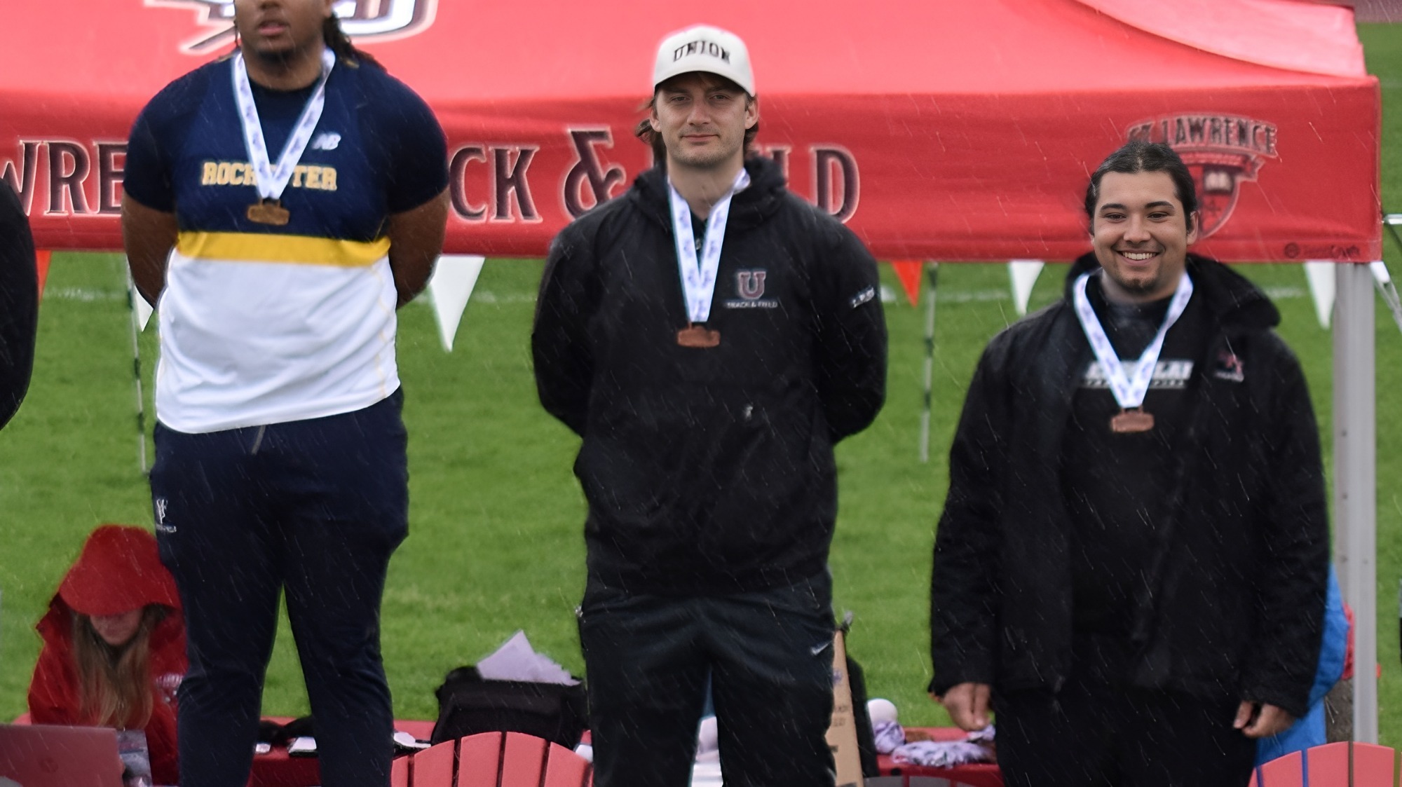 Men looking at the camera on the podium for the shot put