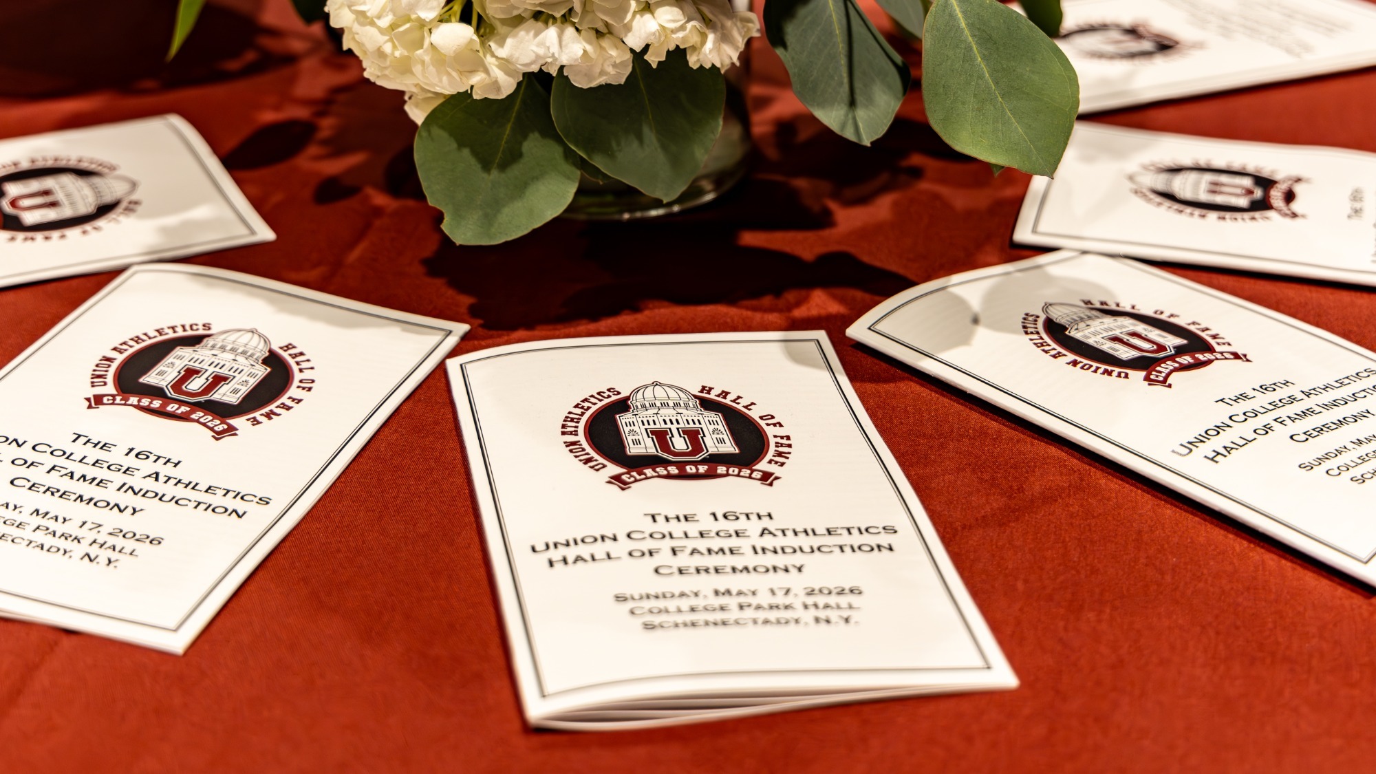 Programs on a table with a flower centerpiece