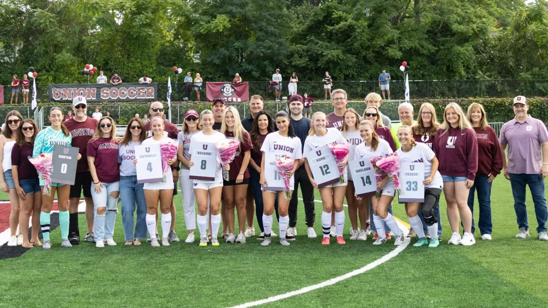 a group photo of women's soccer players and their families