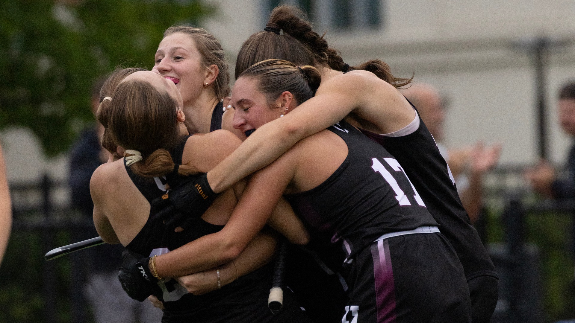 Field hockey players hug after the game-winning goal was scored.