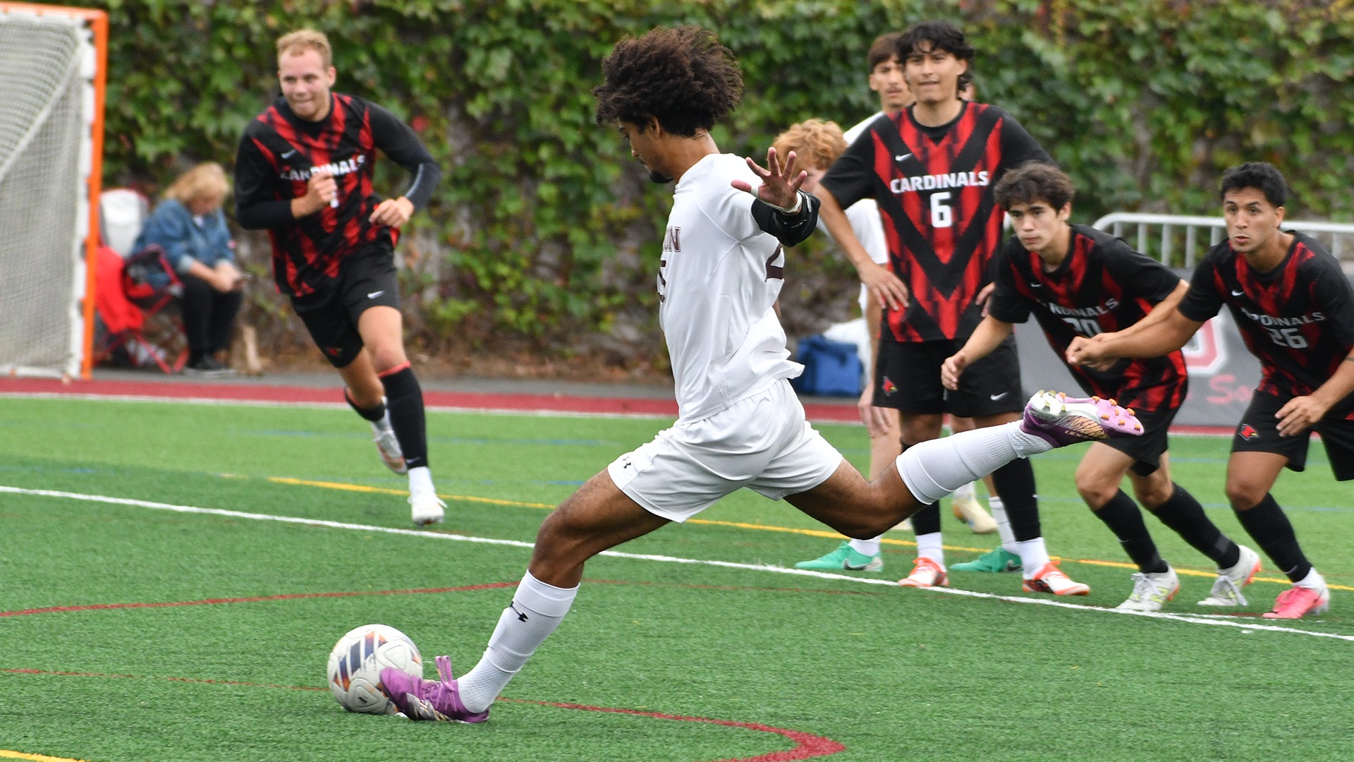 A Union soccer player taking a penalty kick with opponents at the top of the box in the background.