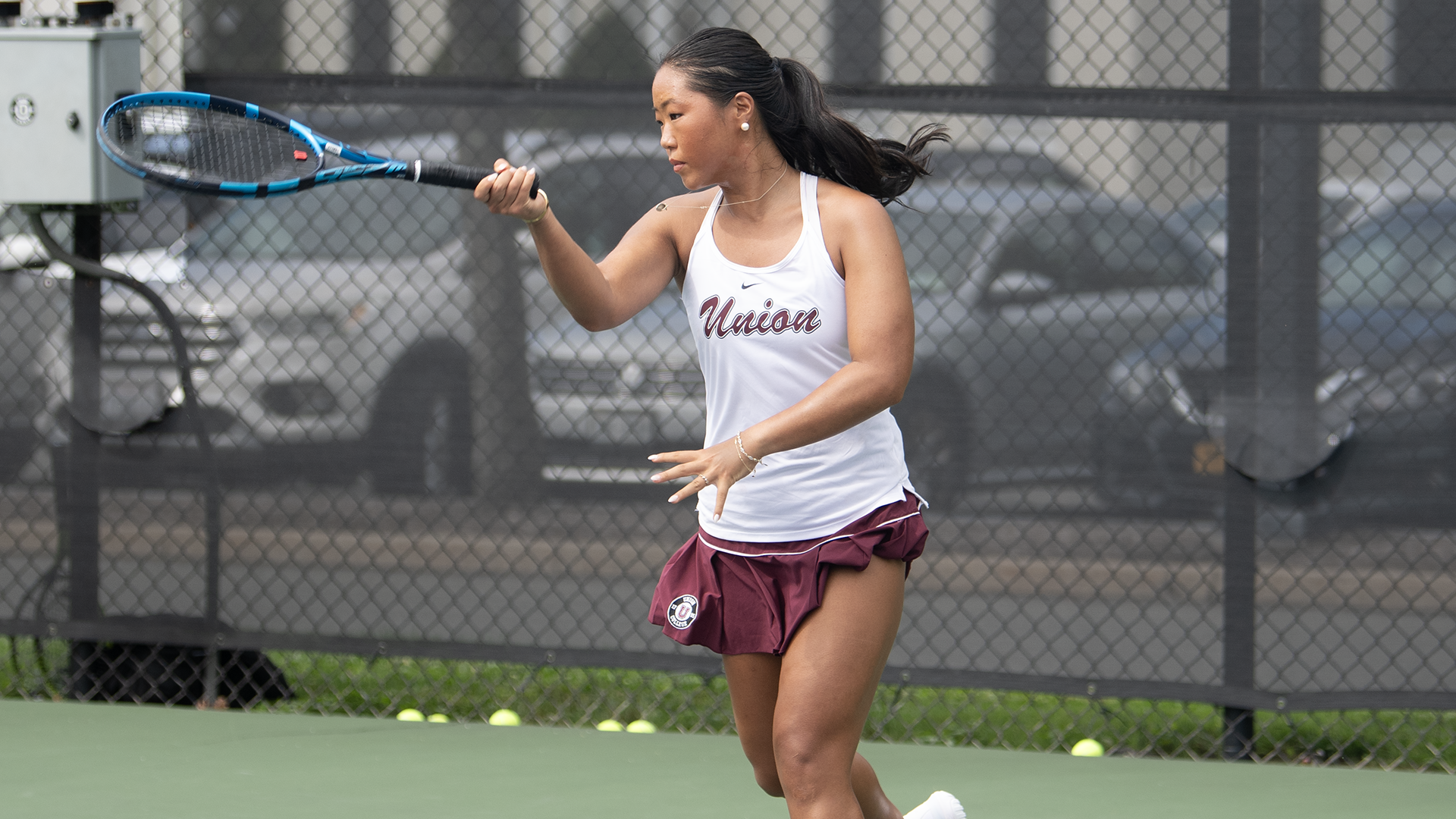 A Union tennis player follows through after hitting a forehand shot.