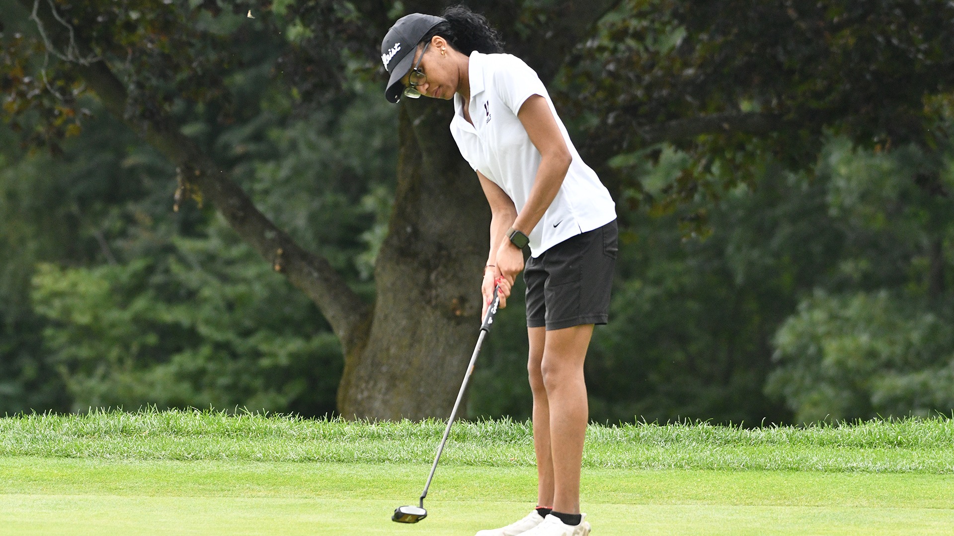 A golfer following through on a putt.