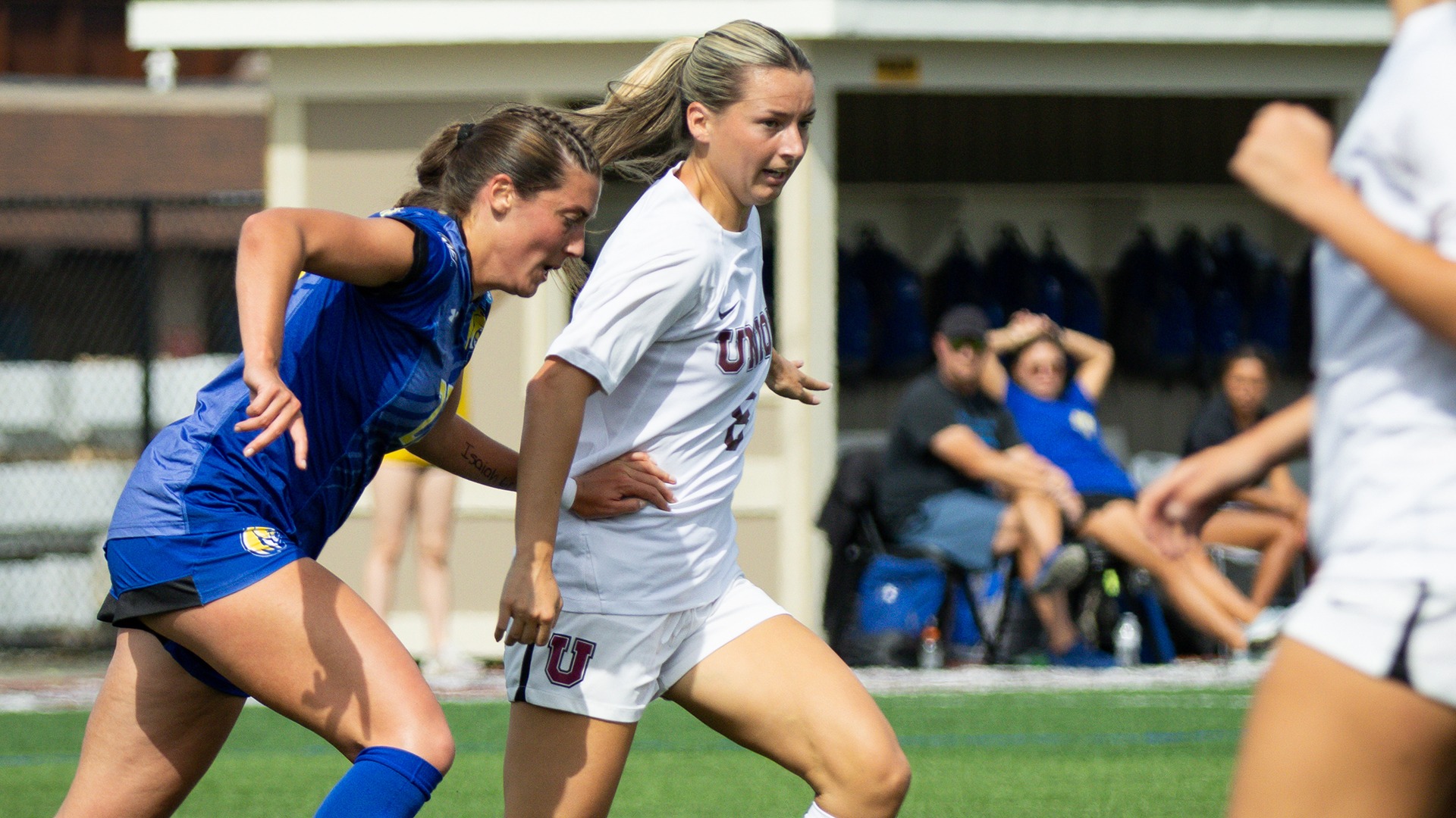 A Union women's soccer play dribbles with a defender in close pursuit.