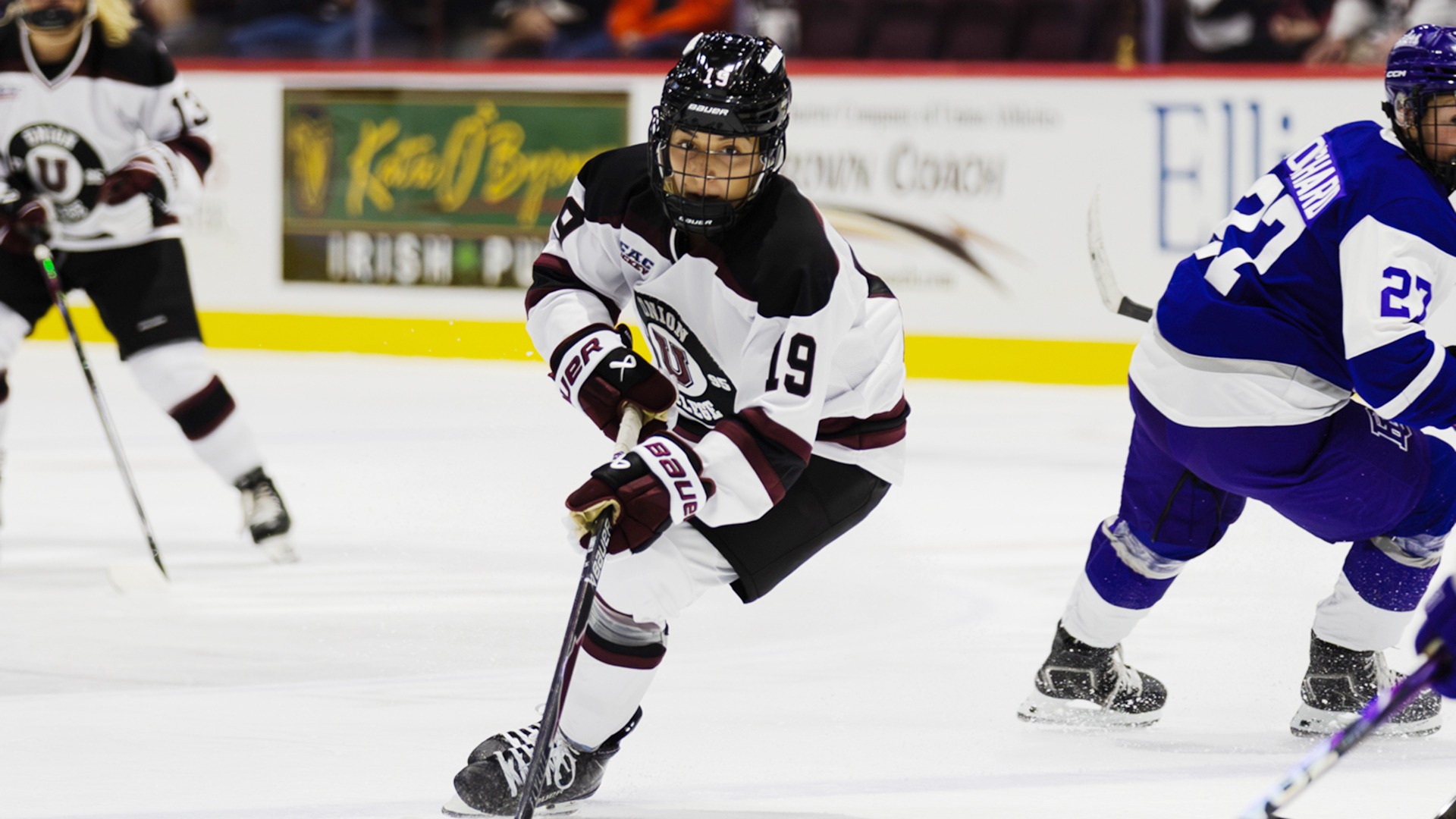 A Union women's hockey player skates toward a puck.