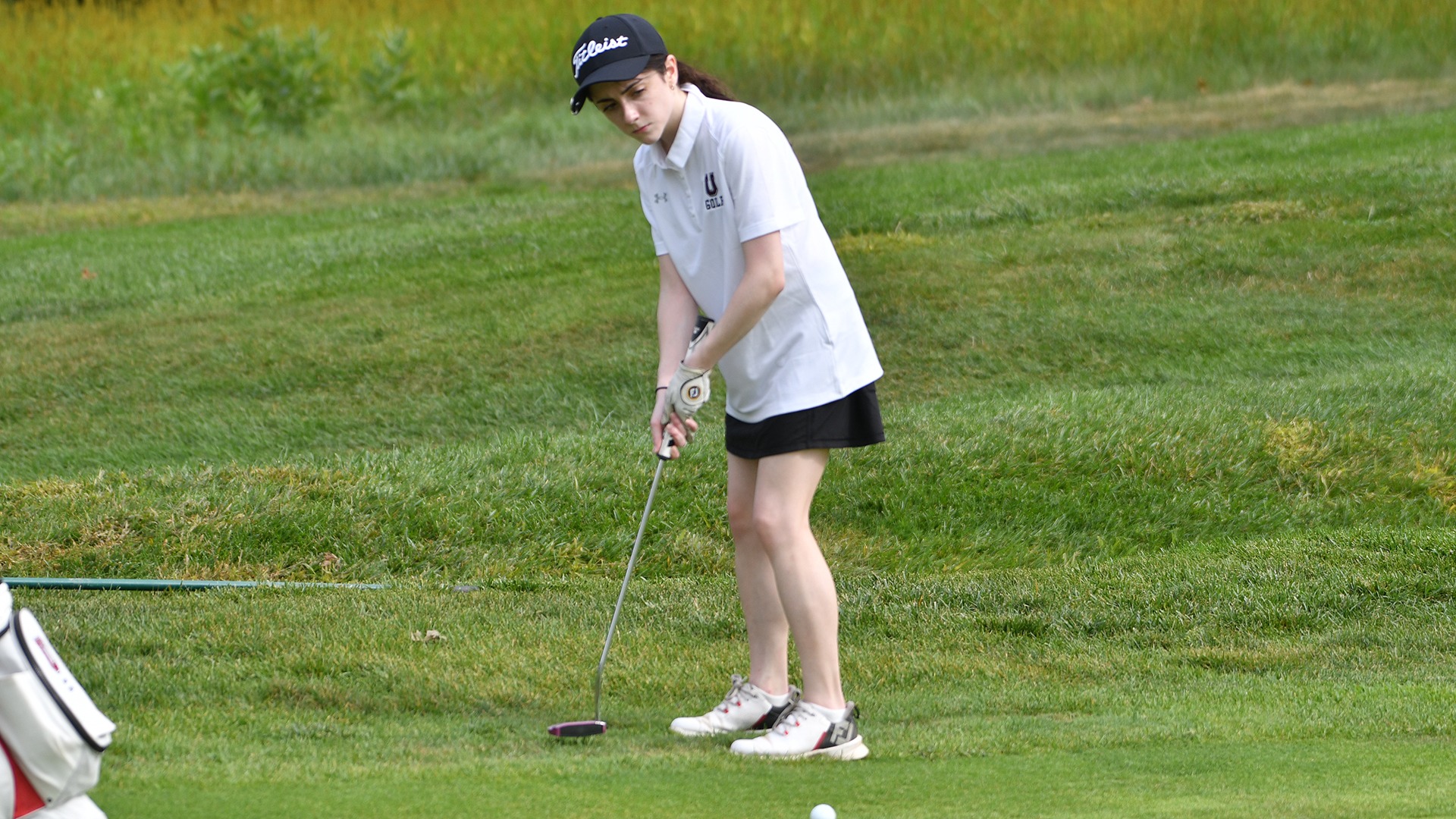 A Union women's golfer putts from just off the green.