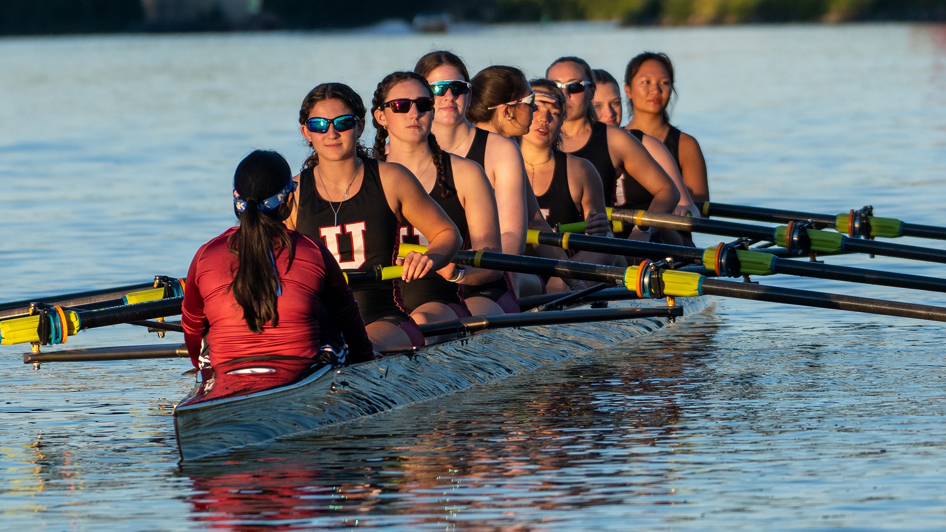 Women's rowers sit in a boat waiting to row.