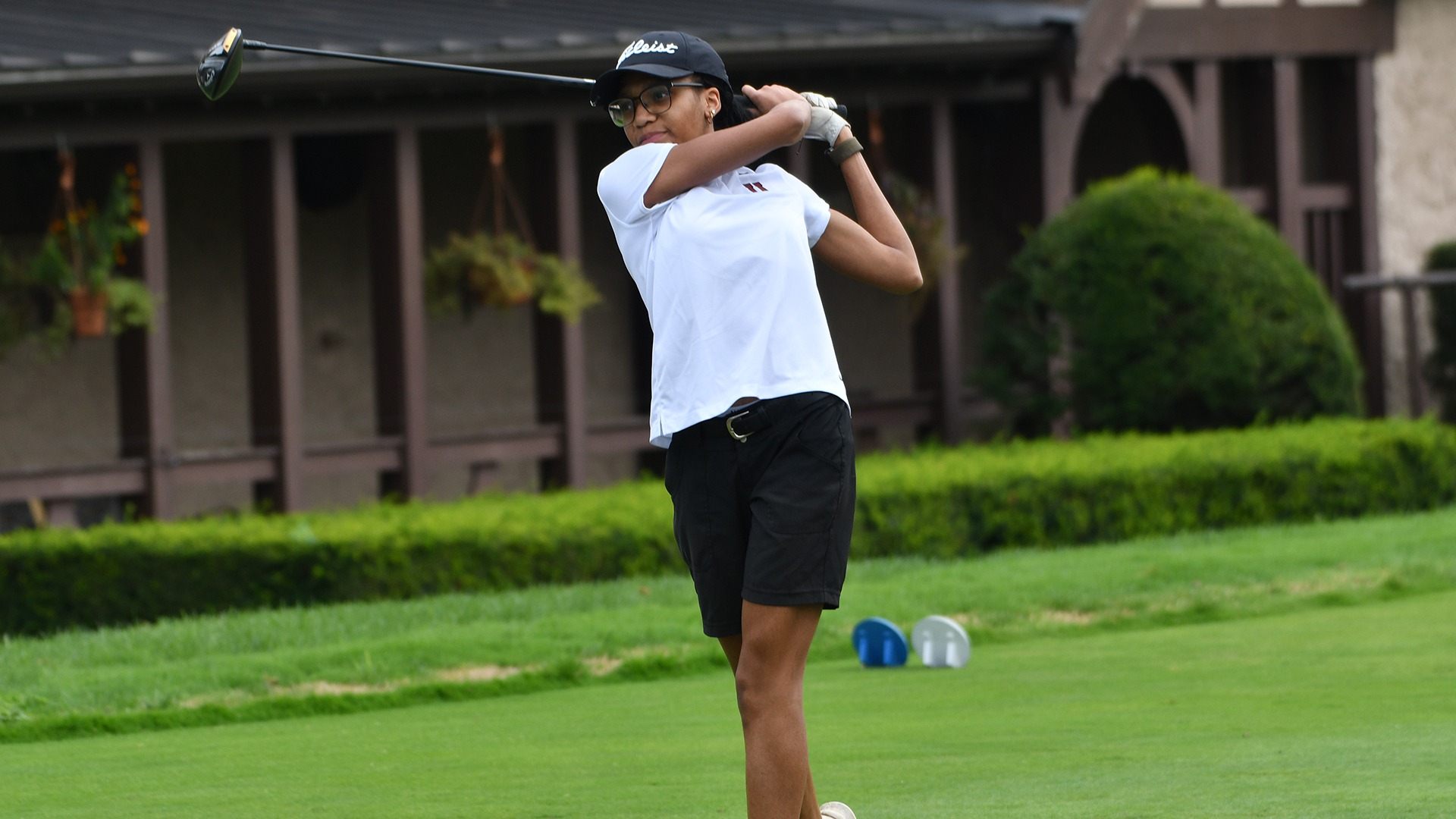 A Union women's golfer follows through after a tee shot.