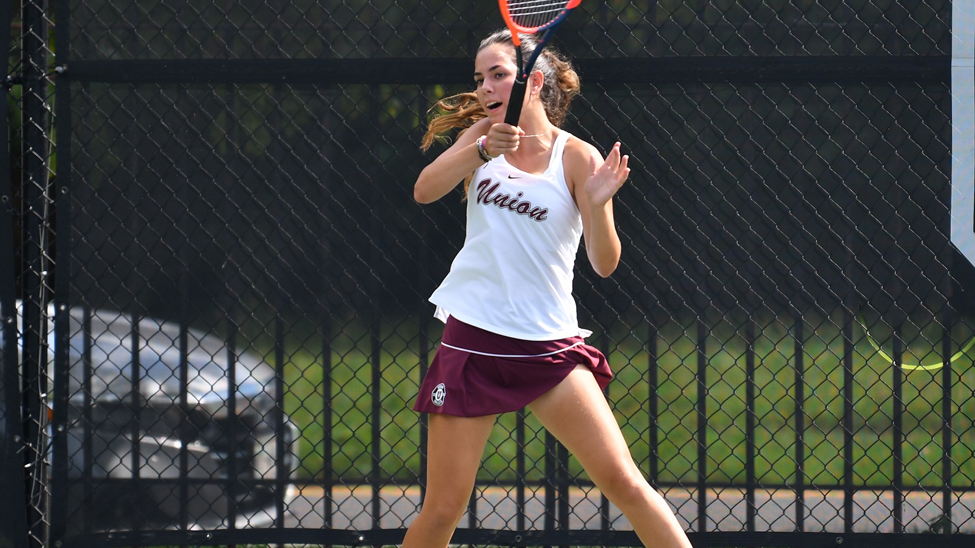 A tennis player follows through after a forehand shot.