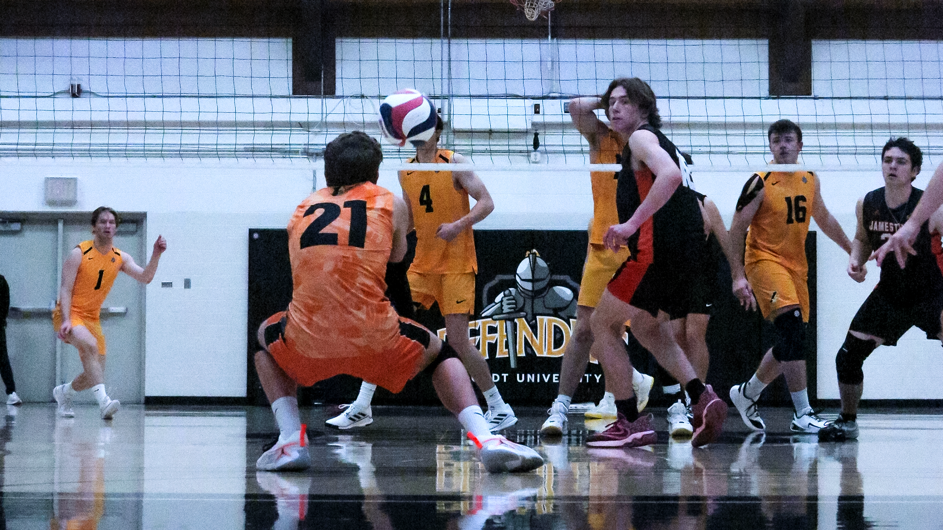 #21 Jackson Holmes (UJ) digging a volleyball from an opposing teams attack