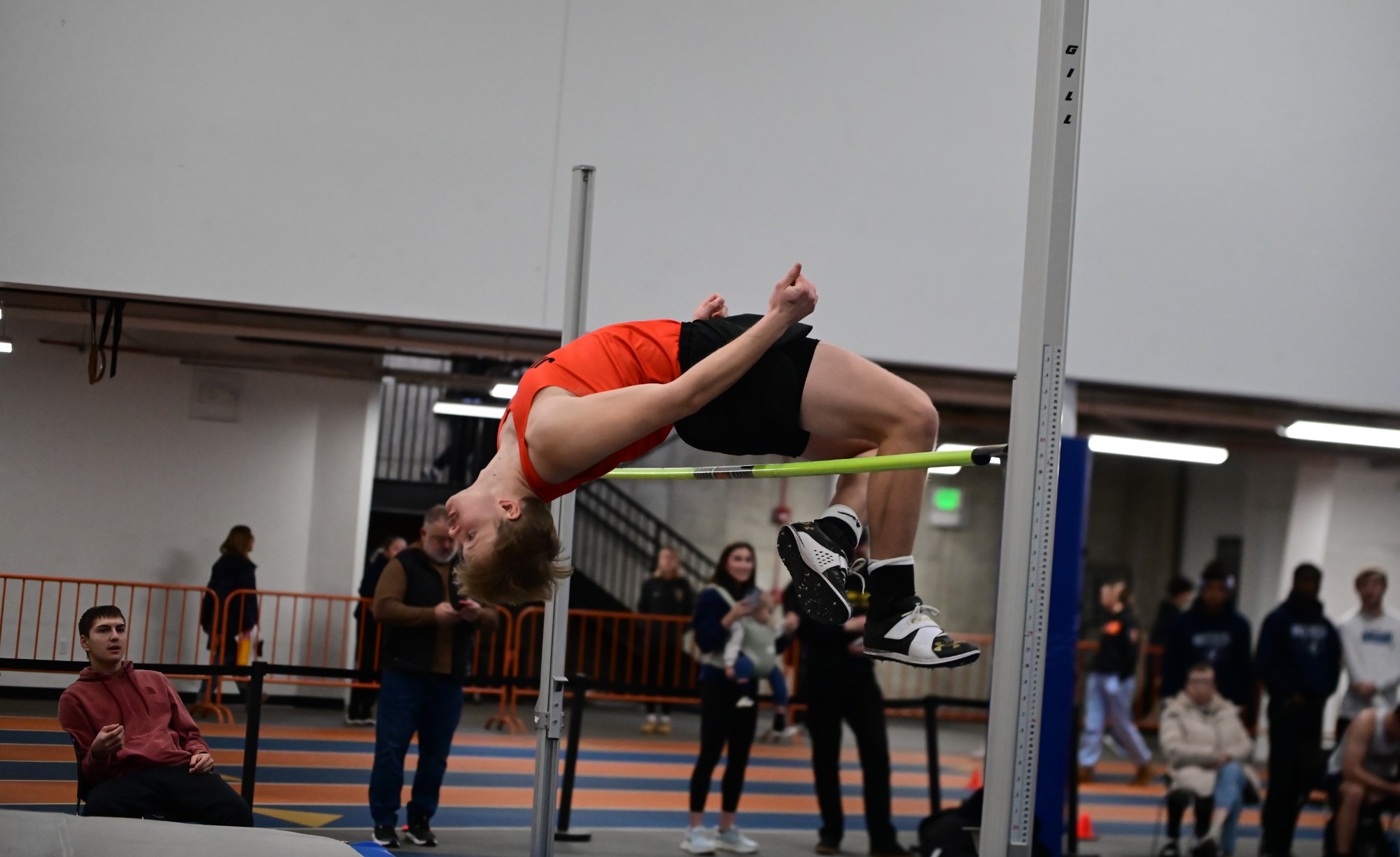 UJ male athlete clearing the high jump bar mid-jump