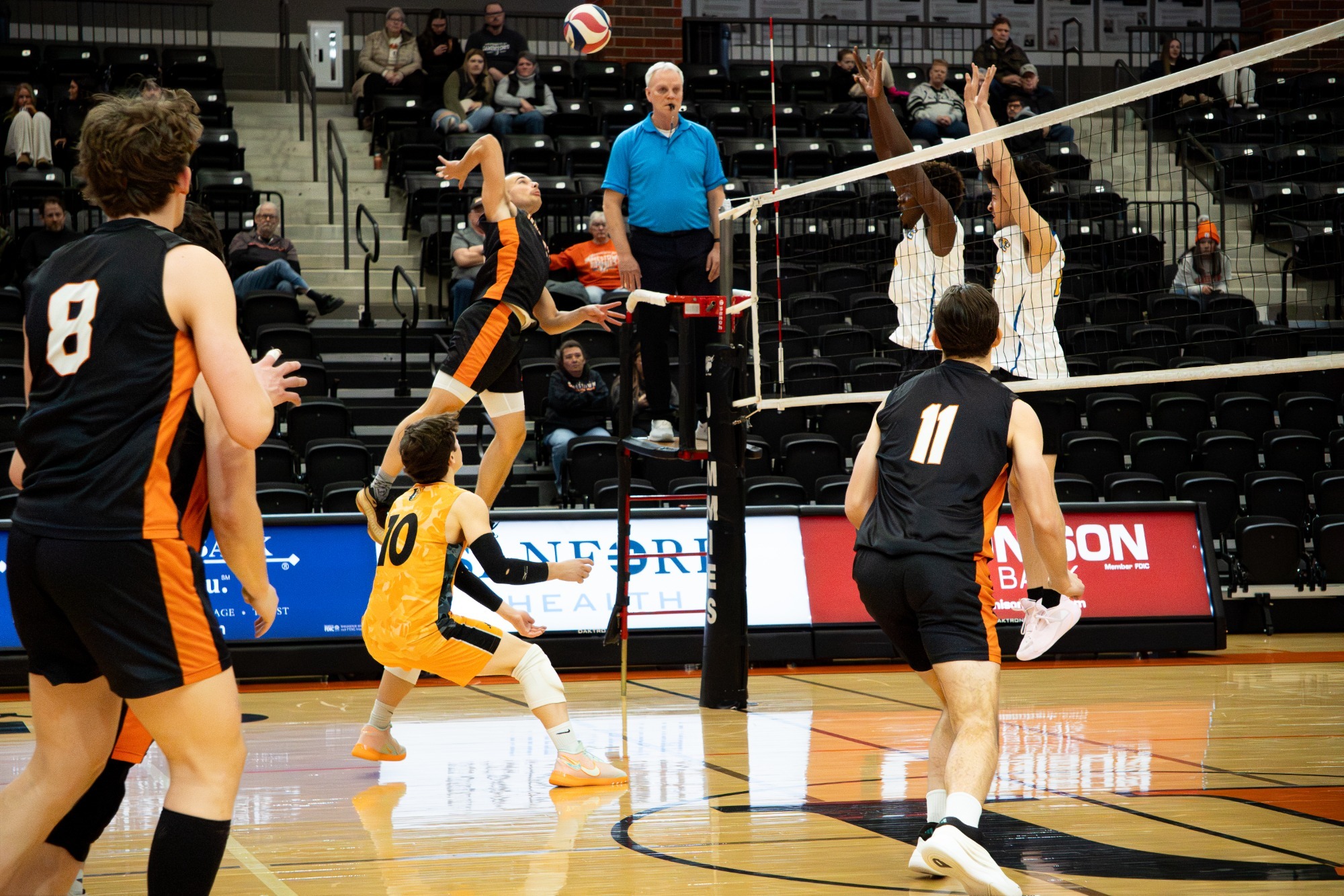 #25 Joshua Crowley attacking the ball at the net during a match