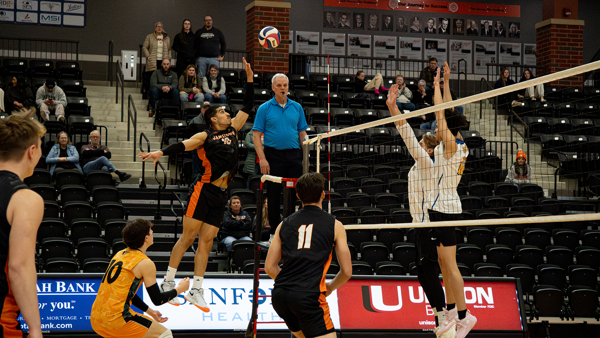 #18 Ladarius Williams attempting to attack the ball at the net facing two blockers