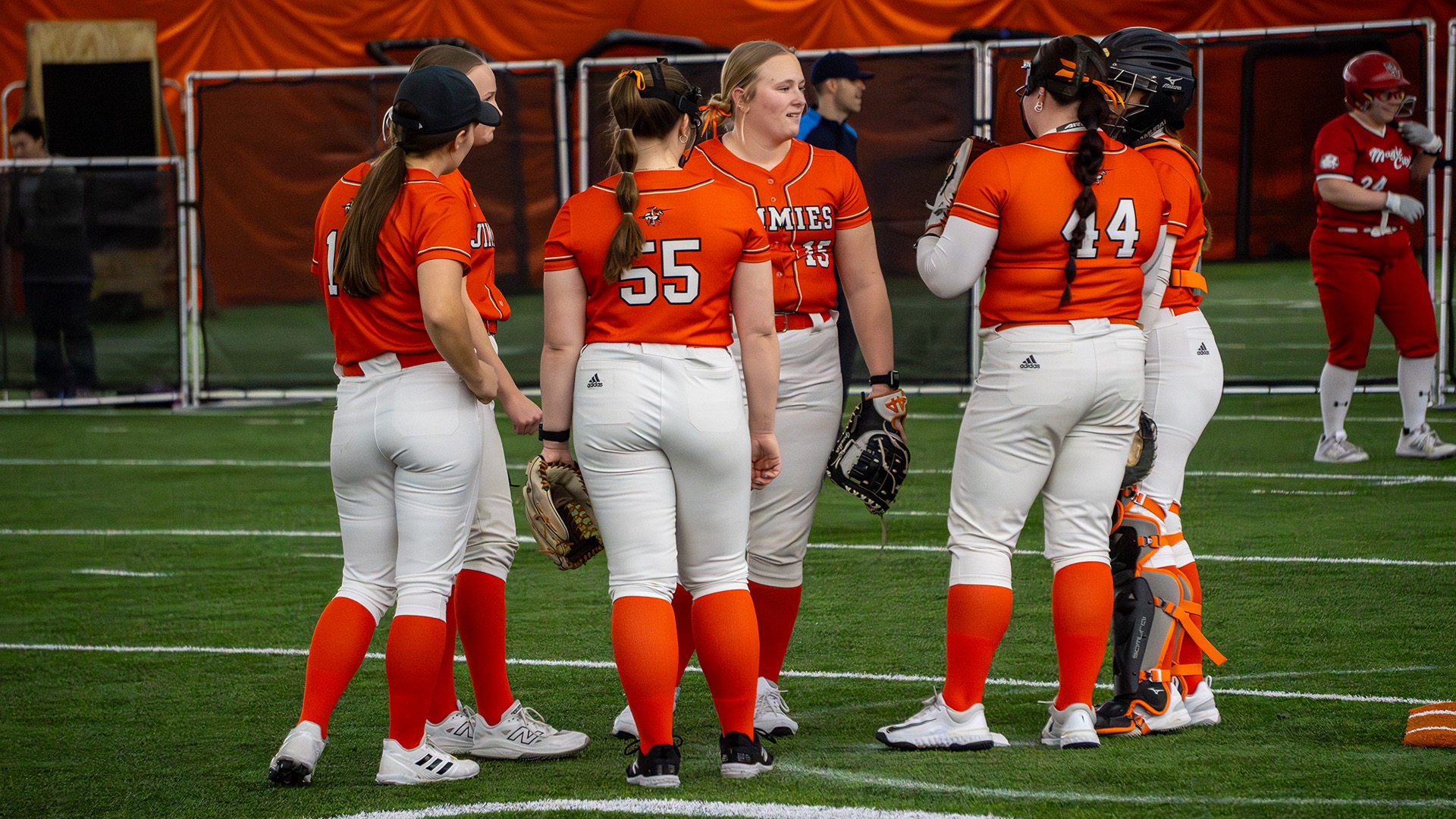 Jamestown #10 Maddie Speath, #33 Amanda Burtch, #44 Hope Ransome, #22 Madelyn Webb, softball team in infield huddle 