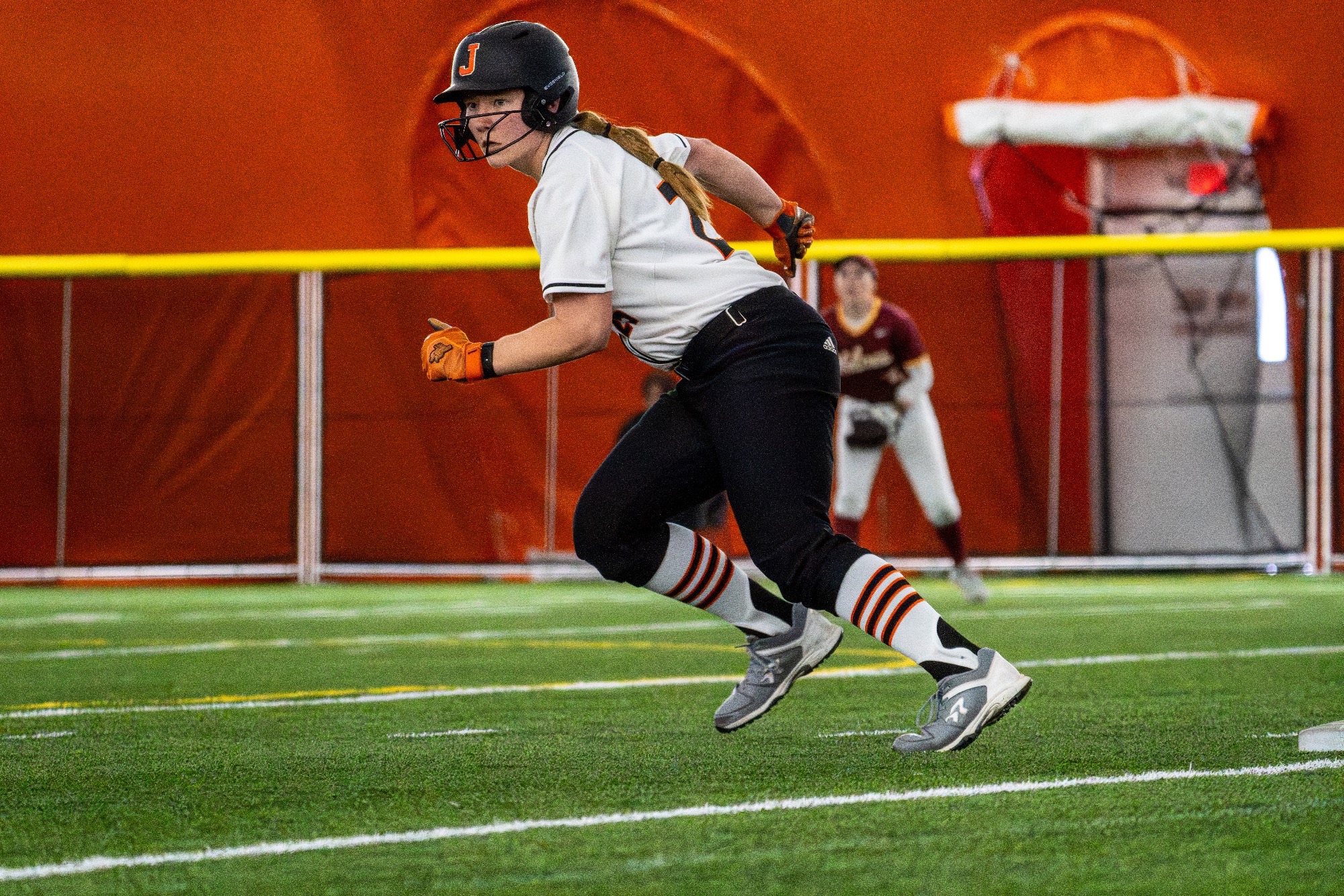 Jamestown #25 Kylie Yanzuk takes off from first in a running start looking at the pitcher in the Nelson Family Bubble April 7, against Northern State University 