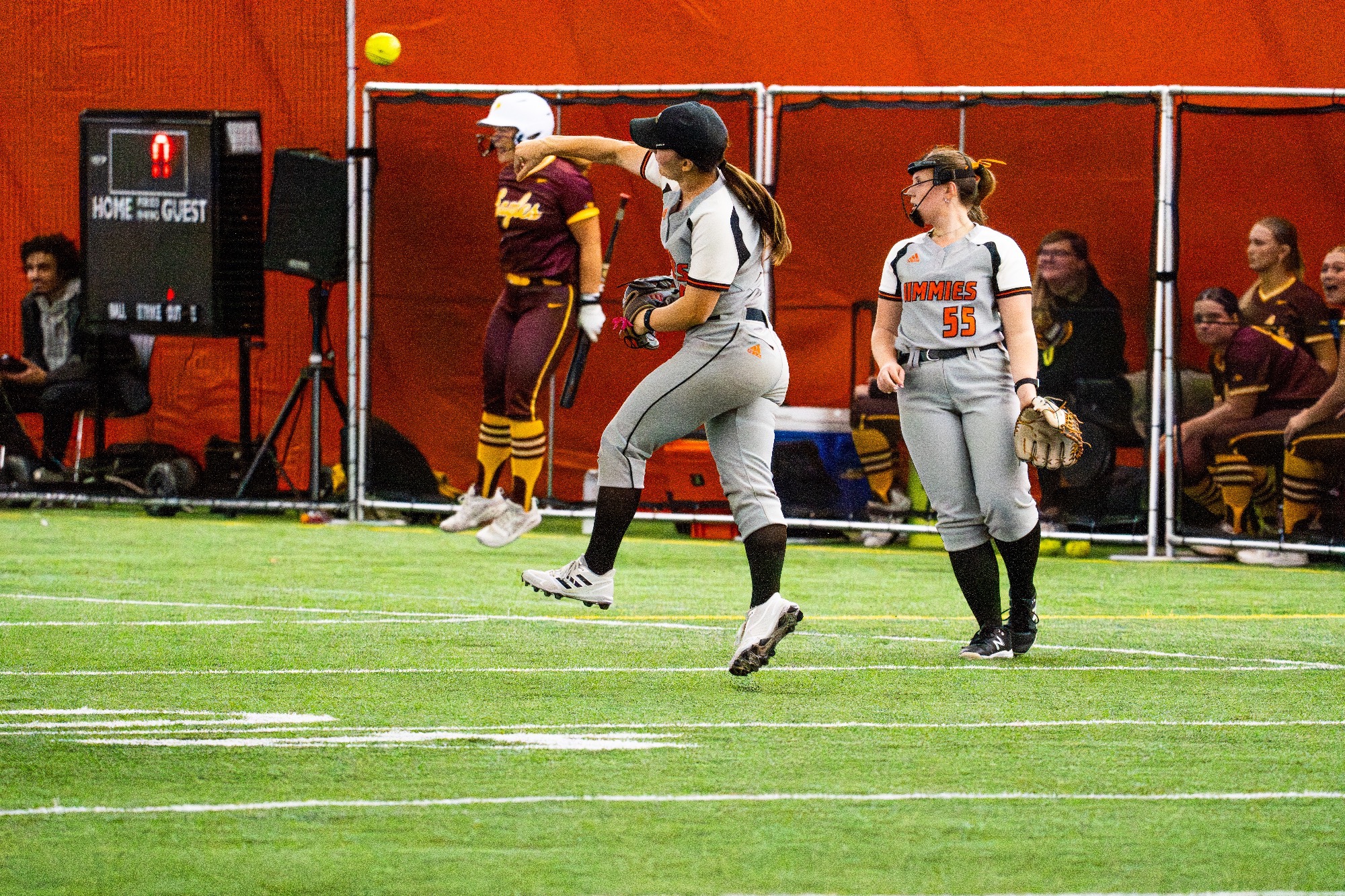Jamestown #10 Maddie Speath makes a jumping throw to first while Jamestown #55 Amanda Burch looks on in the Nelson Family Bubble 