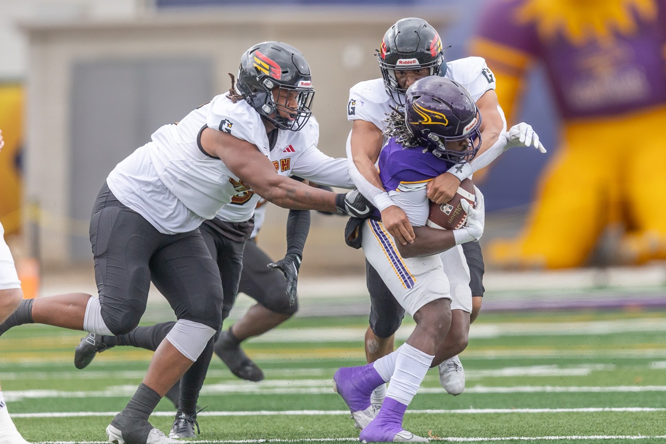 Jevaun Jacobsen and Andre Thompson tackle vs Laurier in OUA semi's