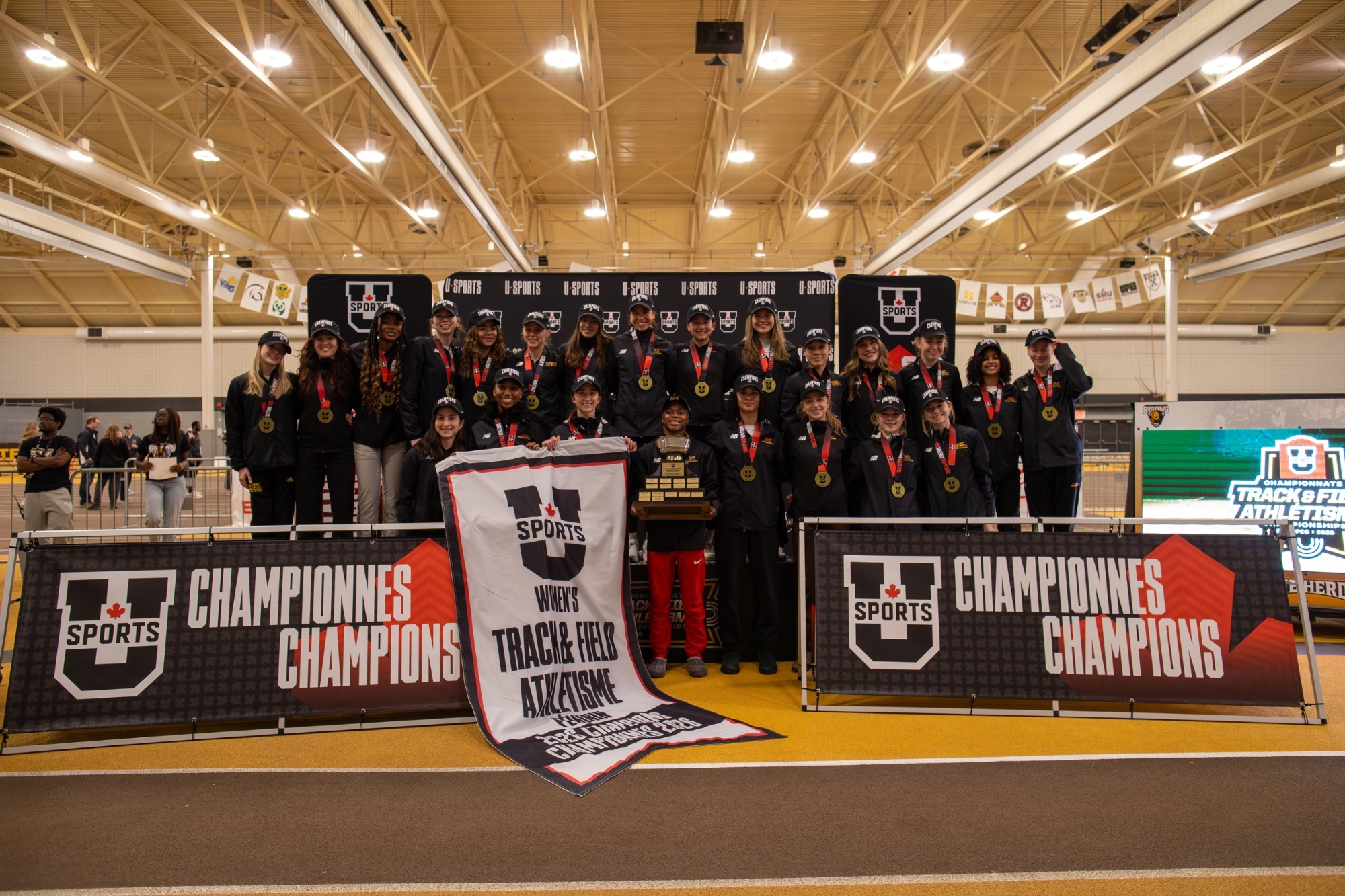 Gryphons women's track and field team with U SPORTS banner after winning 2025-26 national title