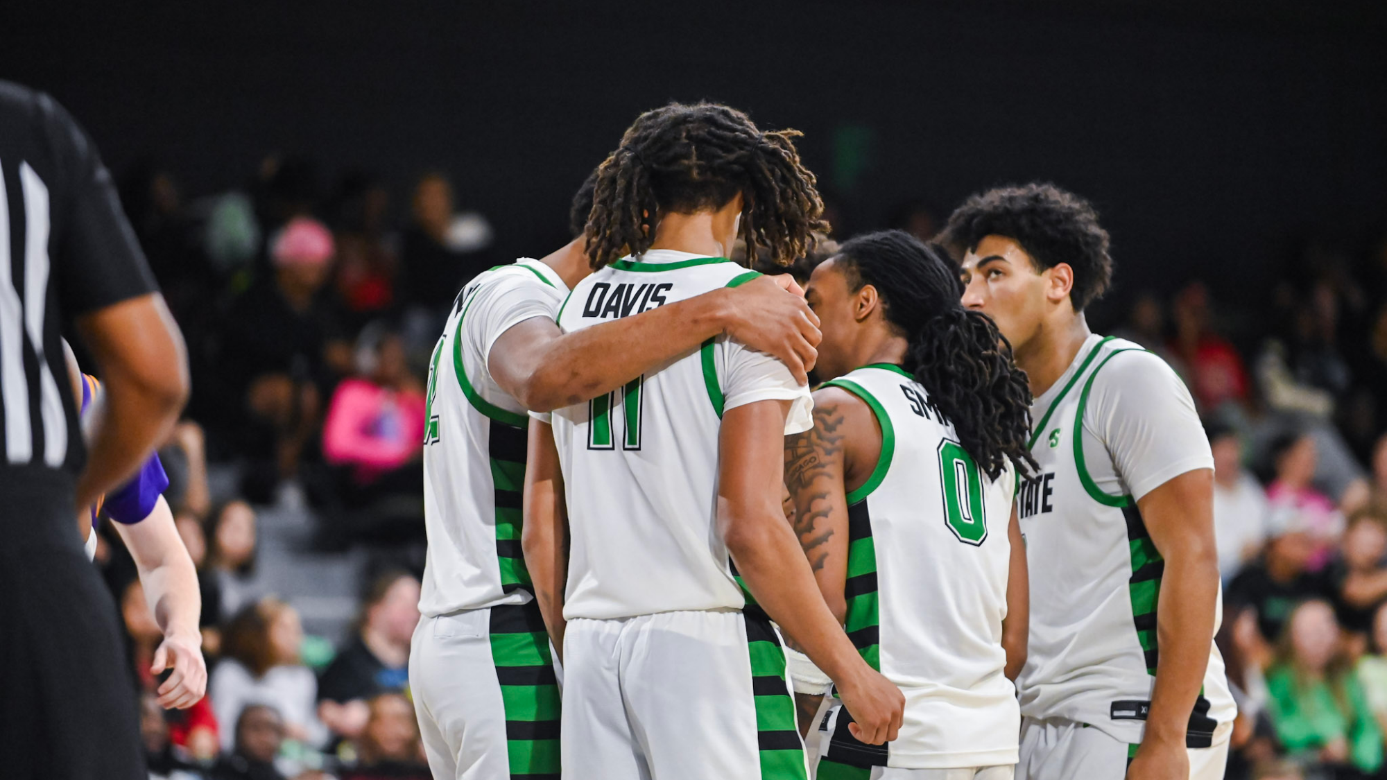 Men's Basketball huddle during a stoppage of play