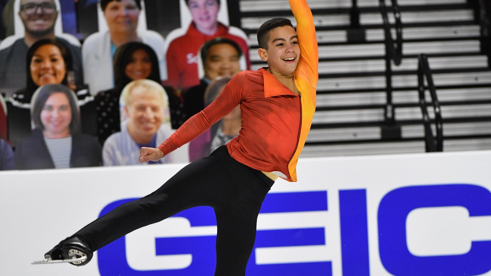 Jacob Sanchez performs his short program in an orange costume at 2021 Toyota U.S. Figure Skating Championships