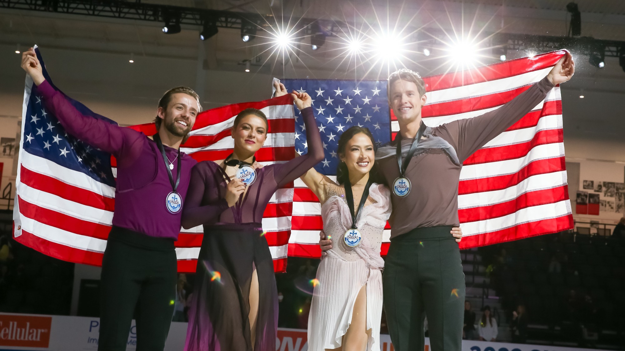 Madison Chock and Evan Bates (right) and Kaitlin Hawayek and Jean-Luc Baker (left) hold up U.S. flags with medals around their necks.