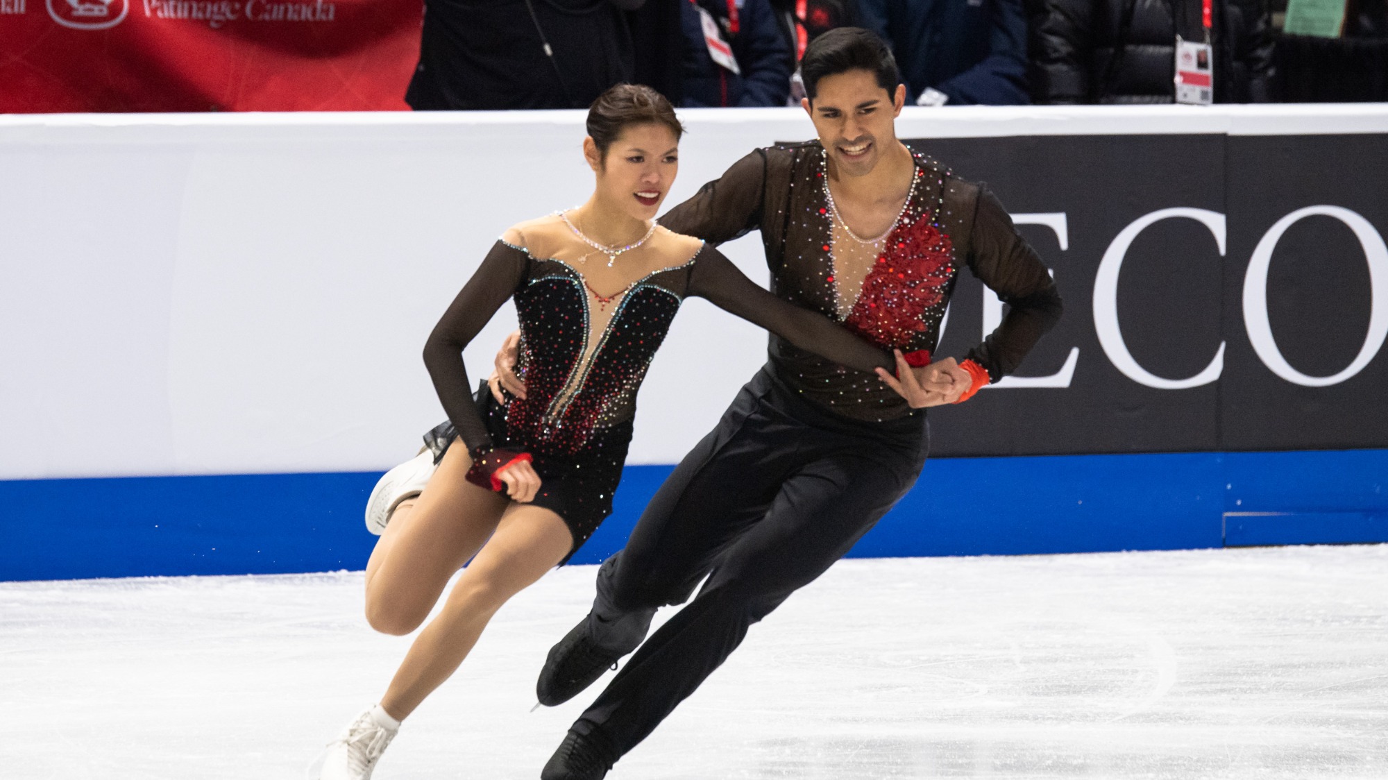 Emily Chan and Spencer Howe perform side by side, his hand on her waist at Skate Canada International.