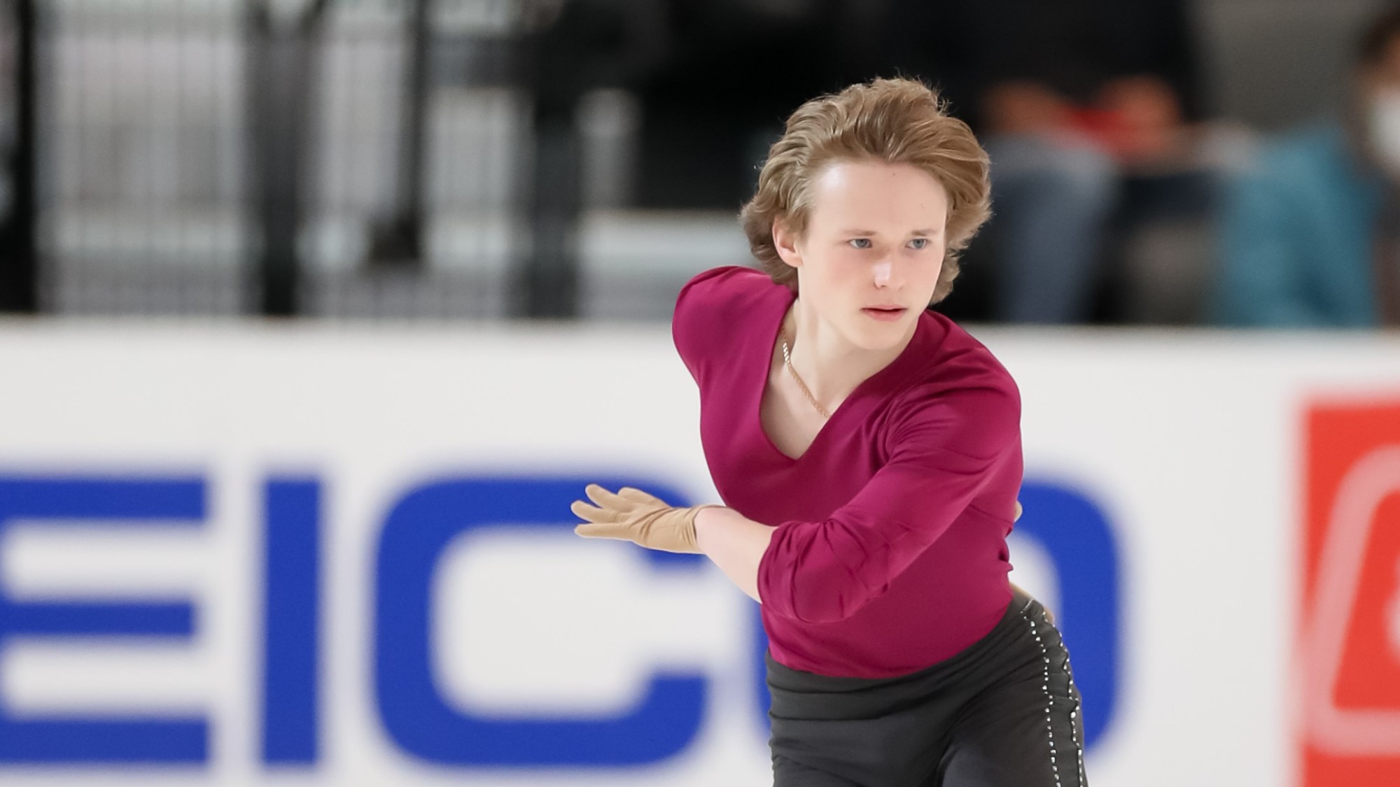 A closeup of Ilia Malinin as he skates at Skate America, an intense look on his face.