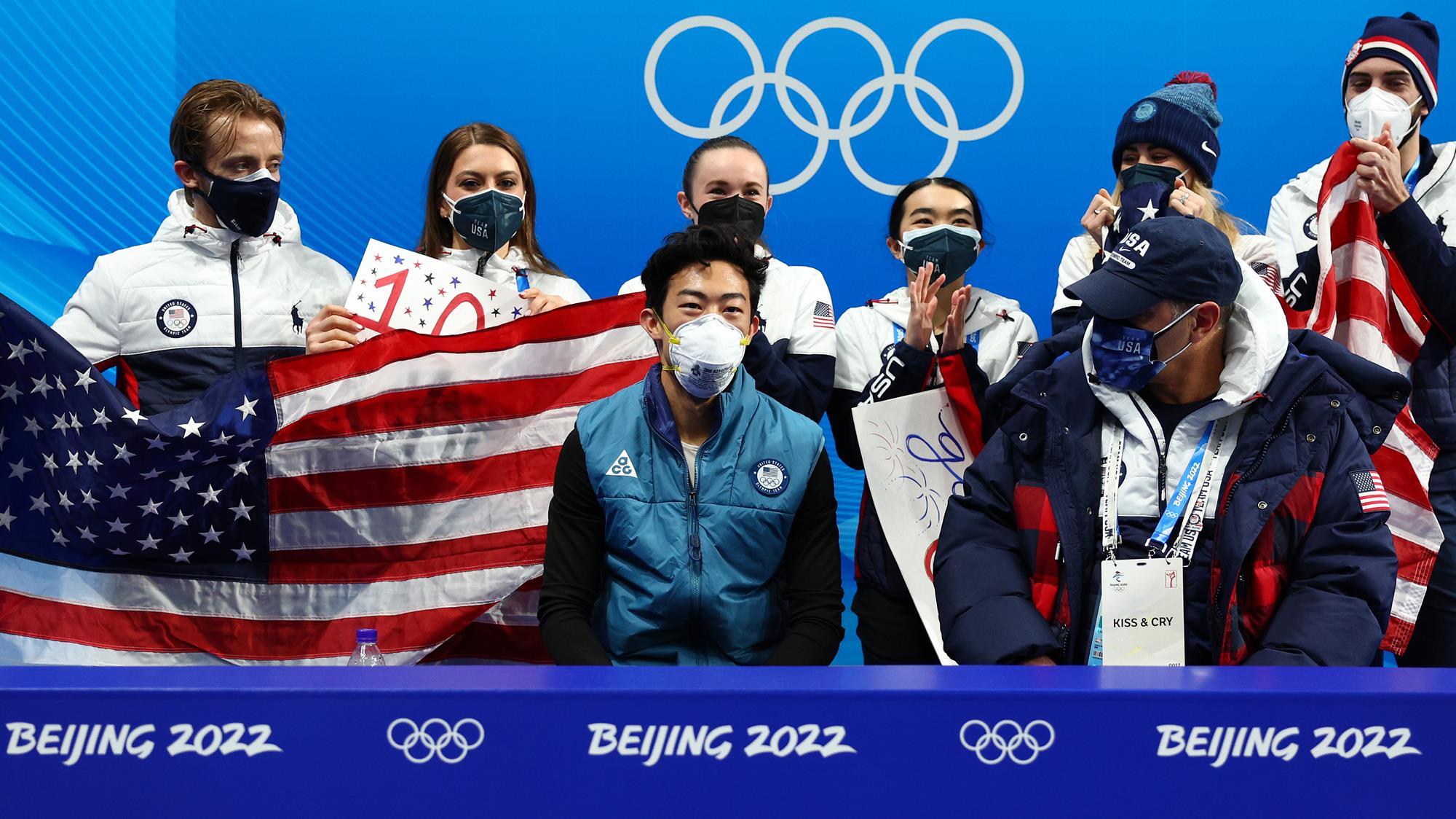 Jean-Luc Baker, Kaitlin Hawayek, Mariah Bell, Karen Chen, Ashley Cain-Gribble and Timothy LeDuc cheer on Nathan Chen in the kiss and cry during day one of the Team Event in Beijing