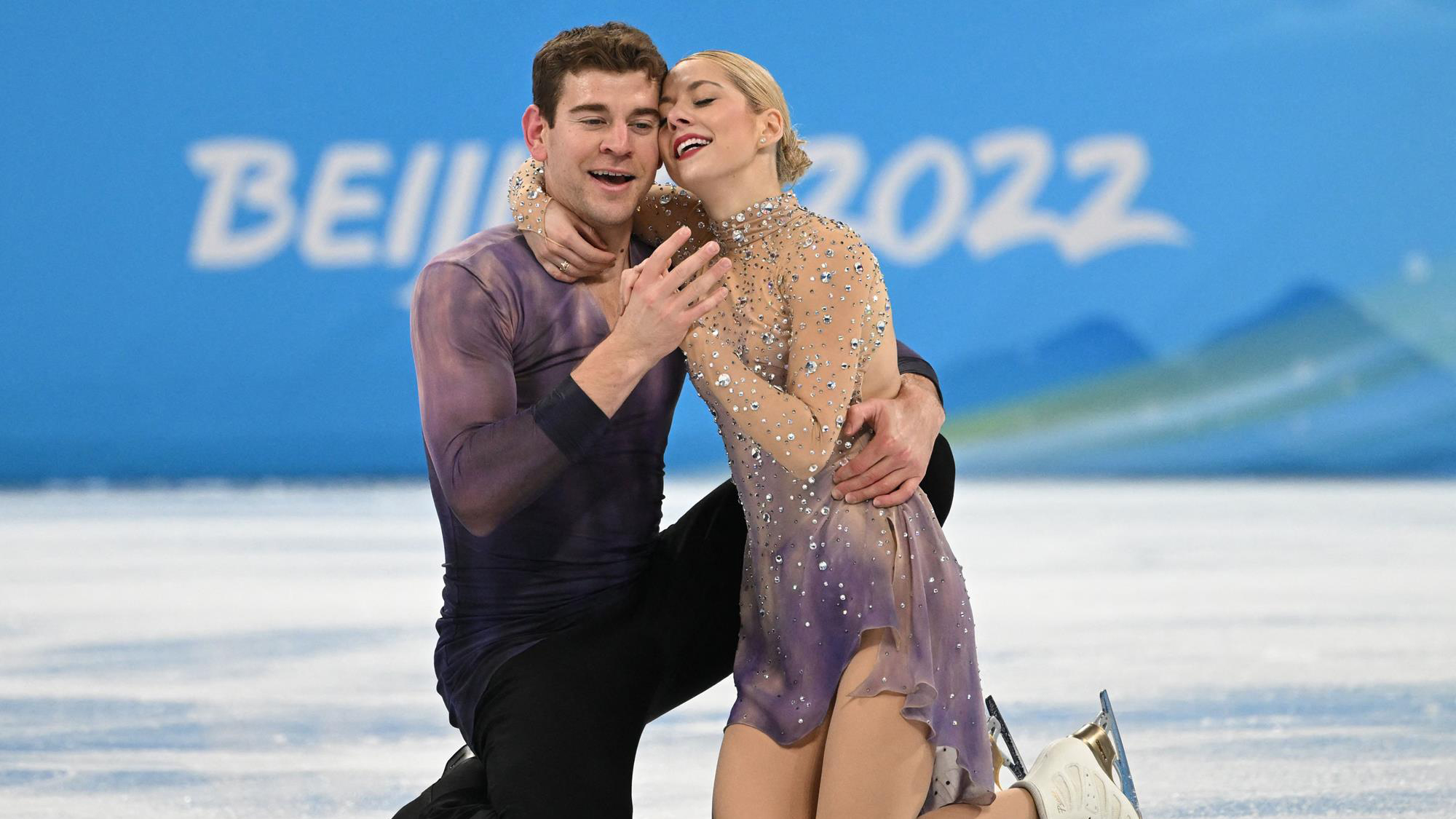 Alexa Knierim and Brandon Frazier kneel together and embrace following their Olympic free skate