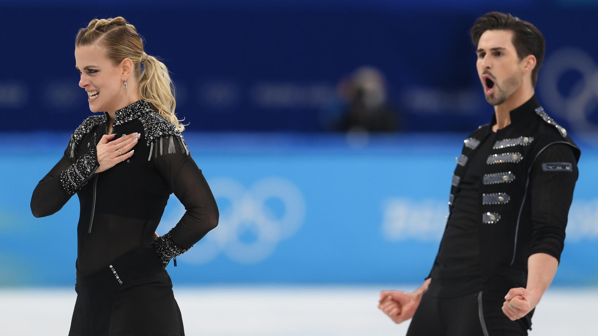Zach Donohue (right) celebrates as he and Madi Hubbell, still in her final pose, finish their rhythm dance at the Winter Olympics.